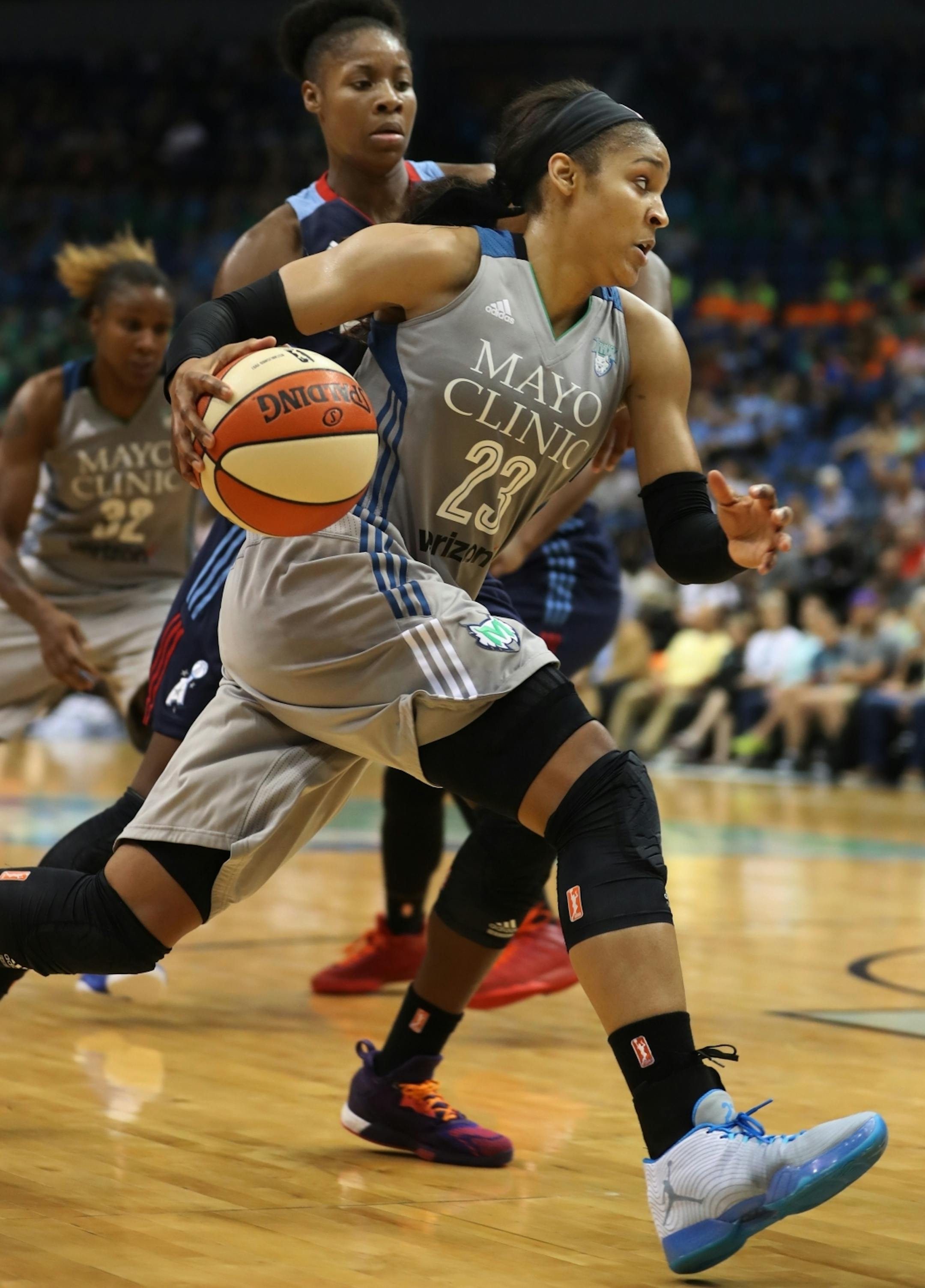 Maya Moore(23) drives by Bria Holmes(32) of the Dream.