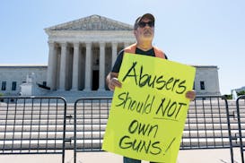 A protester demonstrates in front of the Supreme Court on June 21 in support of a law that prevents people who are subject to a restraining order for 