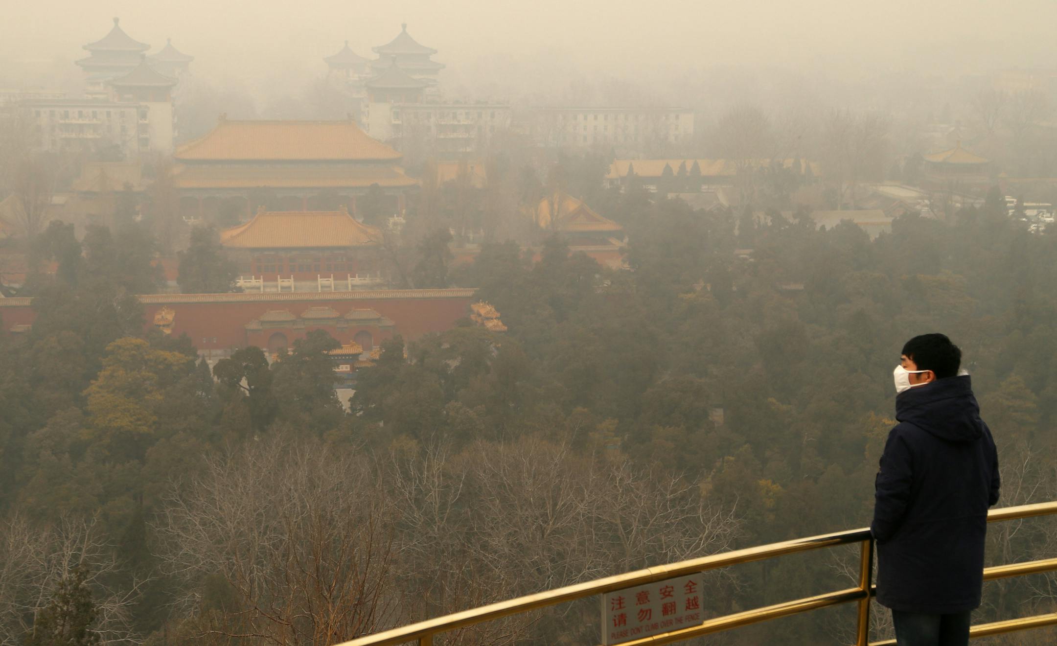 BEIJING, CHINA - FEBRUARY 24: A man wearing mask visits Jingshan Park in the haze on February 24, 2014, in Beijing, China. Altogether 1.43 million sq km of China's land territory, nearly 15 percent of the total, have been covered by persistent smog in recent days, according to news report. (Photo by ChinaFotoPress/Getty Images) ORG XMIT: 475271607