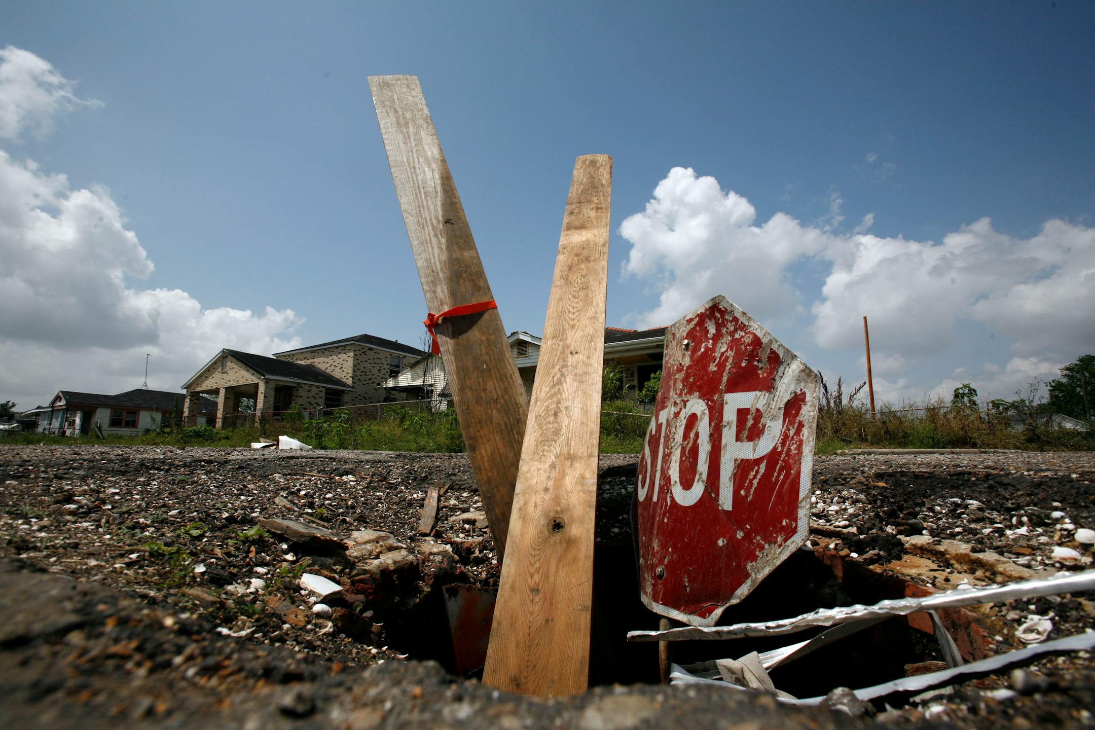 Boards and a stop sign mark an open manhole in the devastated Lower 9th Ward of New Orleans in April 2007.