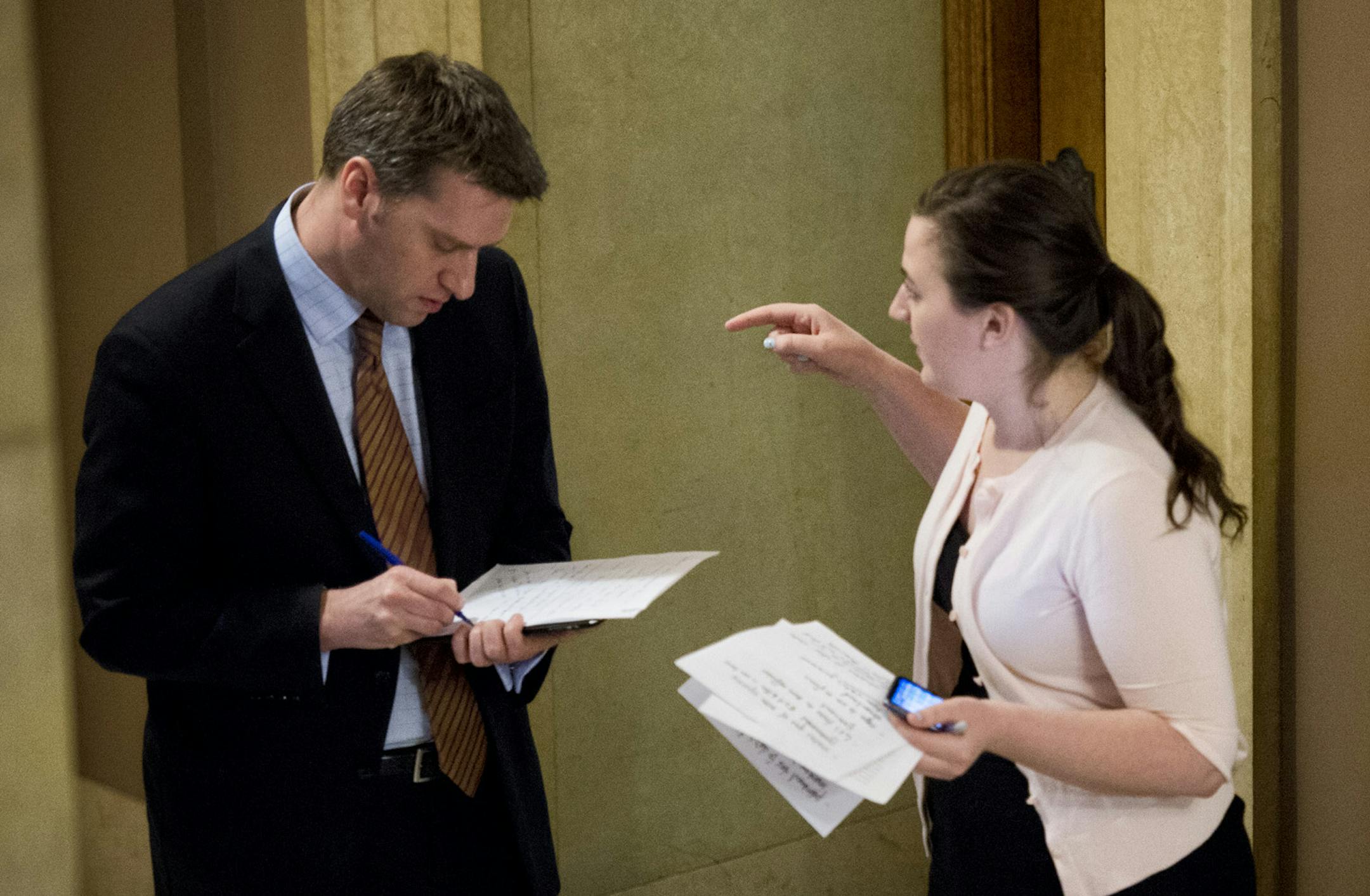Minority Leader Kurt Daudt and Susan Closmore, went over notes in the hallway before rebutting the House DFLers budget plan to the press. On the right is Assistant Minority Leader Rep. Kelby Woodard. House Democrats want those making more than $500,000 to come up with about $854 million over the next two years, paying back K-12 public schools. Tuesday, March 19, 2013. ] GLEN STUBBE * gstubbe@startribune.com