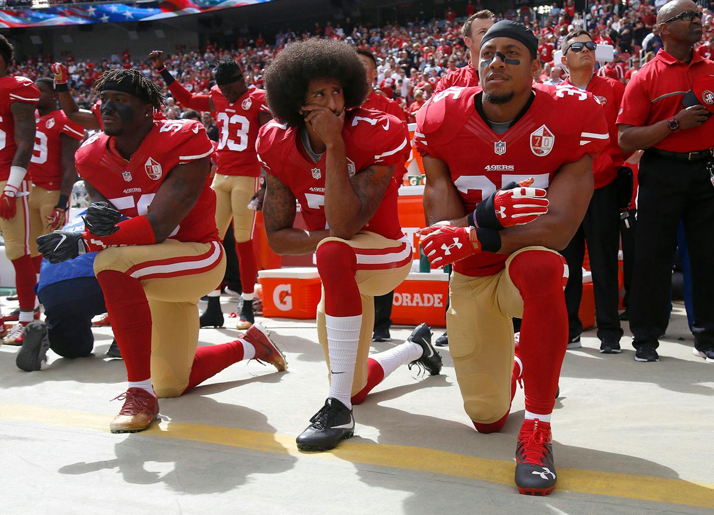 The silent protest of injustice of Colin Kaepernick (middle, kneeling during a 49ers game in 2016 between Eli Harold and Eric Reid) made too many waves for the NFL. The quarterback is out of the league, but the injustice he decried continues.