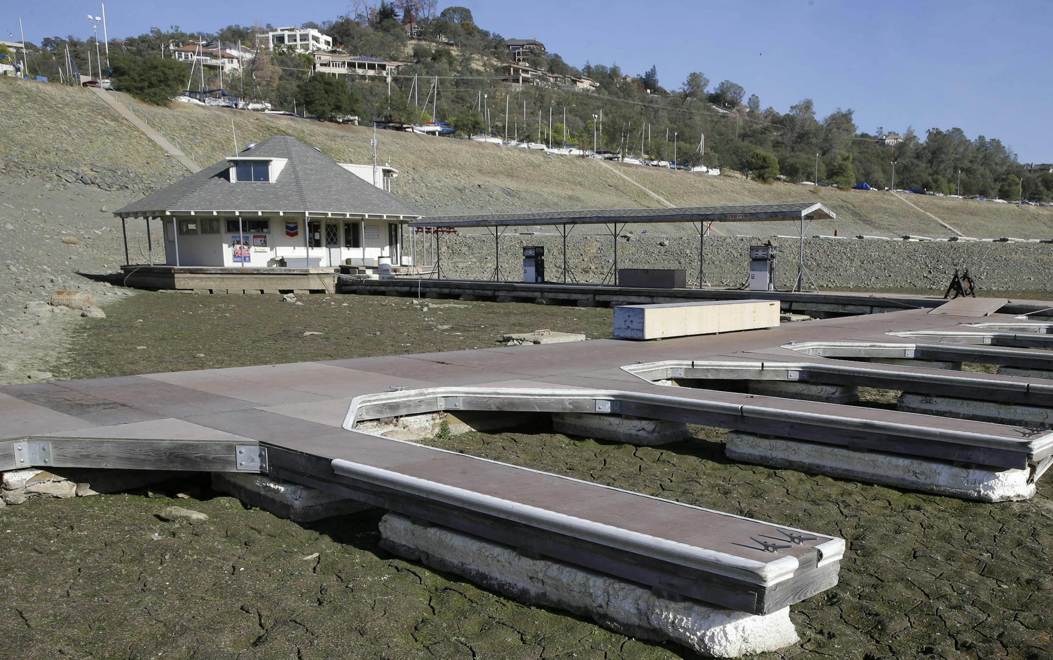 FILE - In this Nov. 17, 2014 file photo, boat slips sit on the dry lake bed at Brown's Marina at Folsom Lake, near Folsom Calif. Global warming worsened record droughts in war-torn Syria and peaceful California, contributing to the unrest that has torn the Middle Eastern country apart, two new studies say. In what scientists say is one of the most detailed and strongest connections between violence and human caused climate change, researchers from Columbia University and the University of Califo