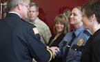St. Paul Fire/Arson Investigation Unit member and St. Paul Police Sgt. Candace Jones is congratulated by St. Paul Fire Chief Tim Butler during a unit 
