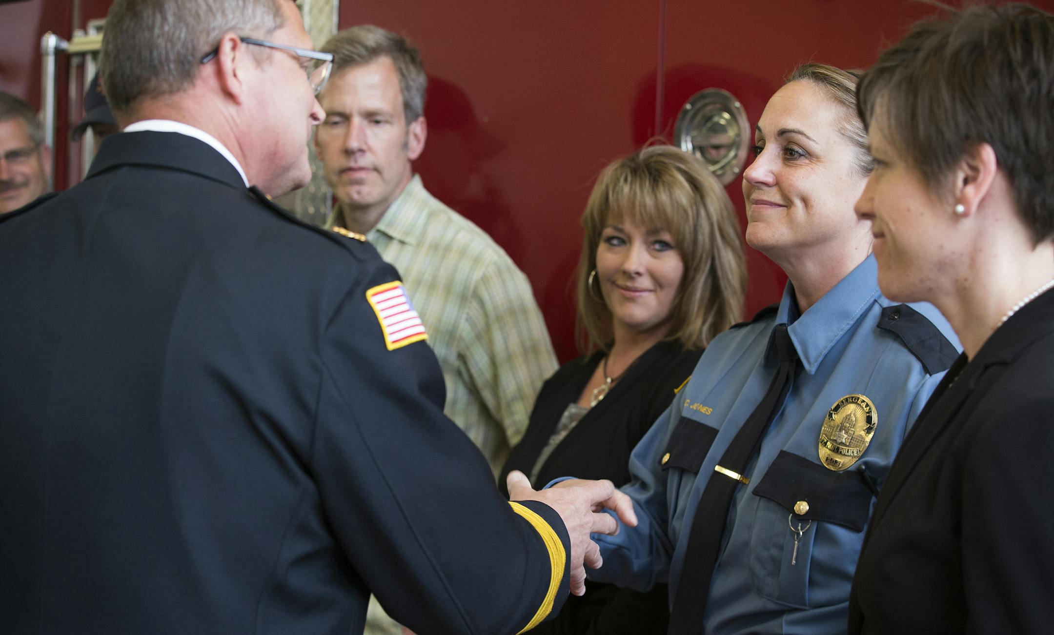 St. Paul Fire/Arson Investigation Unit member and St. Paul Police Sgt. Candace Jones is congratulated by St. Paul Fire Chief Tim Butler during a unit commendation ceremony for the St. Paul Fire/Arson Investigation Unit at Fire Station One in St. Paul on Wednesday, May 6, 2015. ] LEILA NAVIDI leila.navidi@startribune.com /