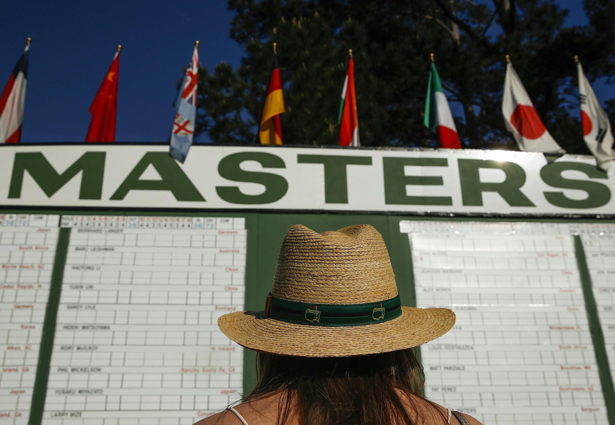 FILE - In this April 5, 2018, file photo, Anna Lee Lavarnway looks at the leaderboard during the first round at the Masters golf tournament in Augusta, Ga. Augusta National decided Friday, March 13, 2020, to postpone the Masters because of the spread of the coronavirus. Club chairman Fred Ridley says he hopes postponing the event puts Augusta National in the best position to host the Masters and its other two events at some later date. Ridley did not say when it would be held. (AP Photo/Charlie