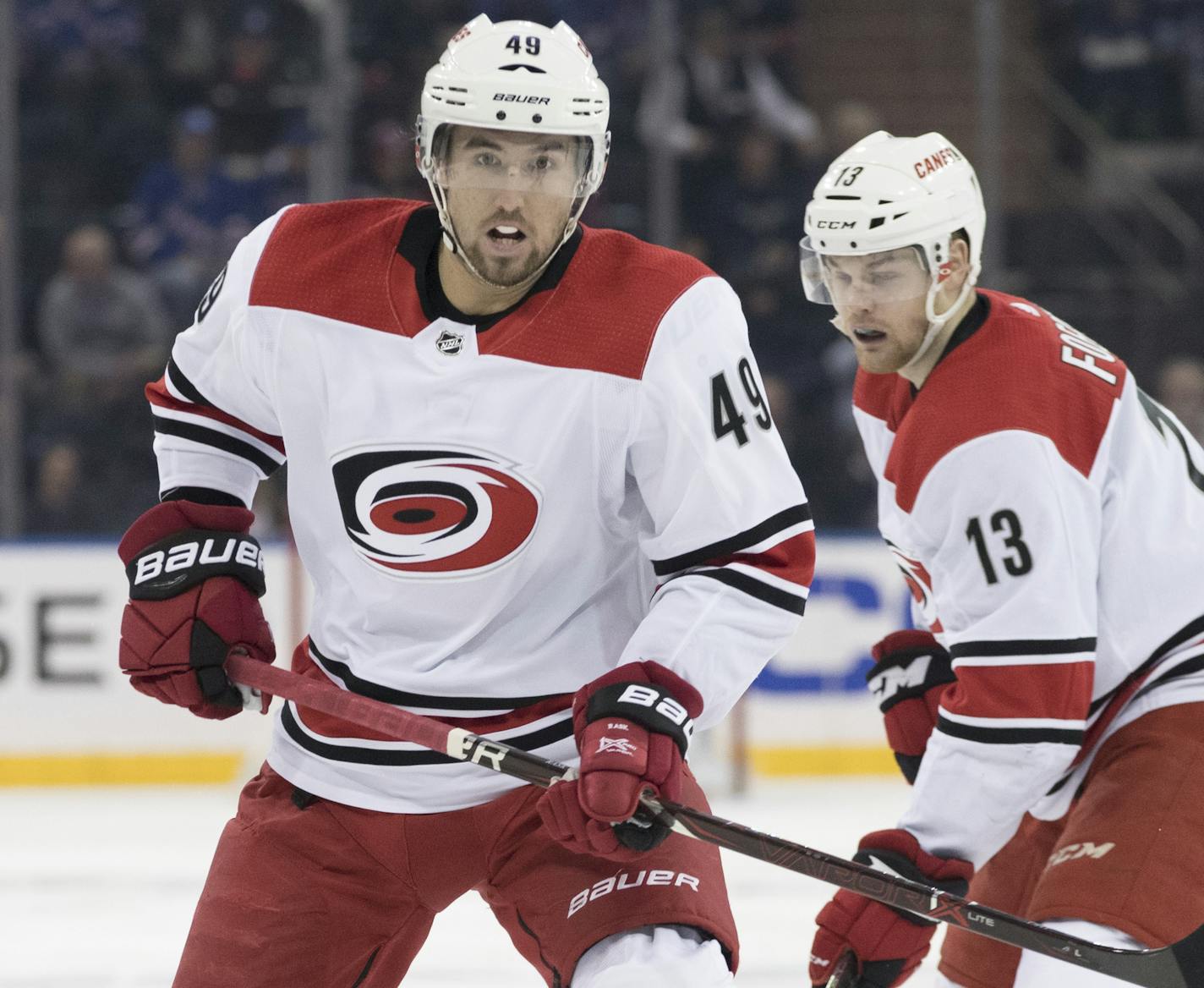 Carolina Hurricanes center Victor Rask (49) and left wing Warren Foegele (13) watch a loose puck during the first period of an NHL hockey game against the New York Rangers, Tuesday, Jan. 15, 2019, at Madison Square Garden in New York. (AP Photo/Mary Altaffer)