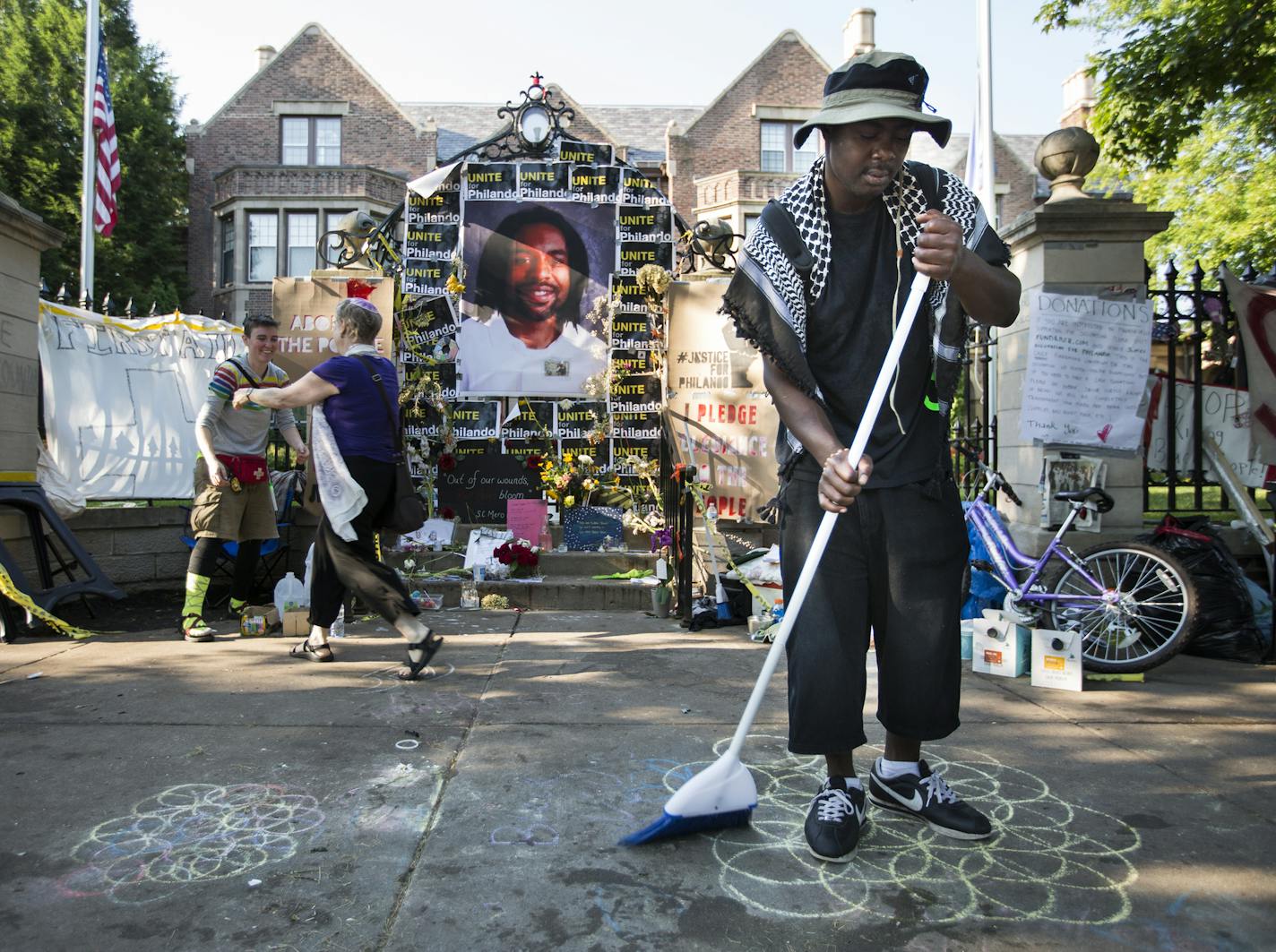 Henry Habu of Minneapolis sweeps the sidewalk outside the Governor's residence in St. Paul. ] (Leila Navidi/Star Tribune) leila.navidi@startribune.com BACKGROUND INFORMATION: Monday, July 18, 2016 at the Governor's residence in St. Paul. Protesters of the shooting death of Philando Castile stood their ground on the sidewalk outside the Governor's residence after the St. Paul Police opened Summit Avenue back up to traffic early Monday morning.