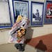 FILE - In this Dec. 17, 2014 file photo, a poster for the movie "The Interview" is carried away by a worker after being pulled from a display case at 