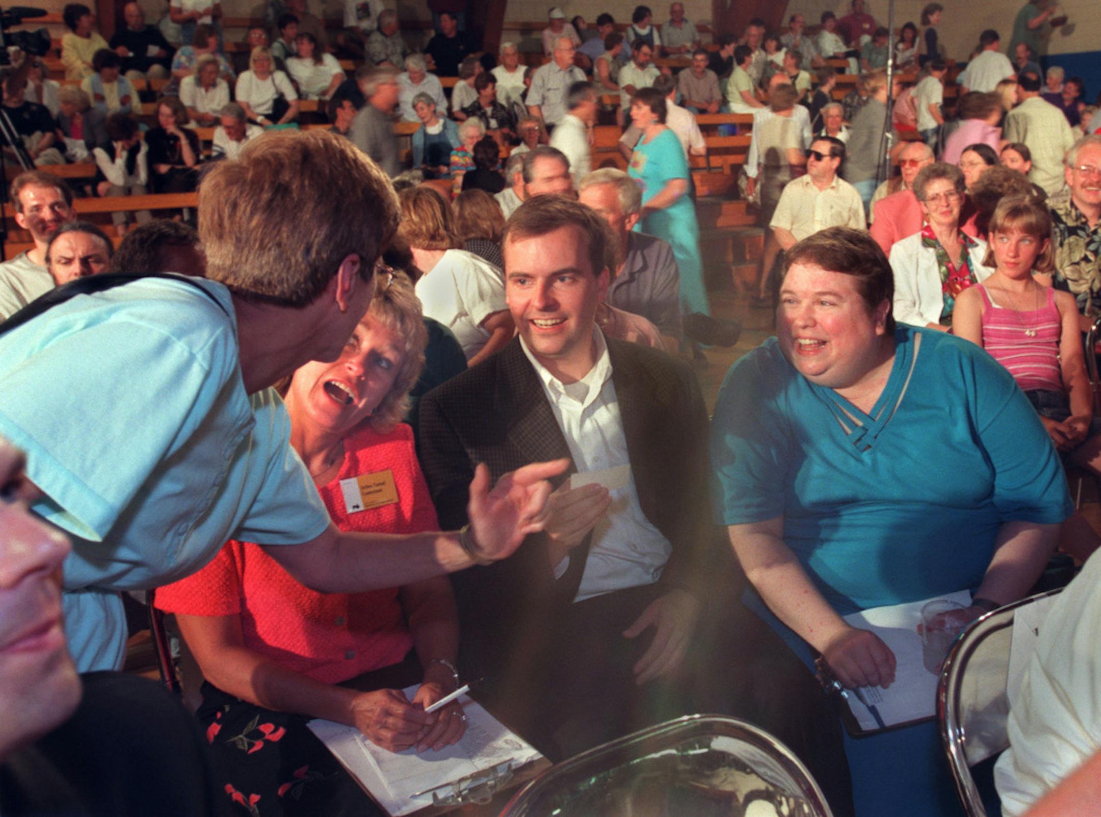 The Great American Think-Off competition held in New York Mills. -- (Three of the Think-Off contestants laugh with an audience member. (Left to right) The contestants are Debra Tastad, a registered nurse from Nisswa, Mn., Taylor Howard, a Boston computer programmer and Lauri Lalko, a community college English instructor from Arizona. Tastad argued that science is more dangerous than religion and Howard and Lalko said religion is more dangerous than science.