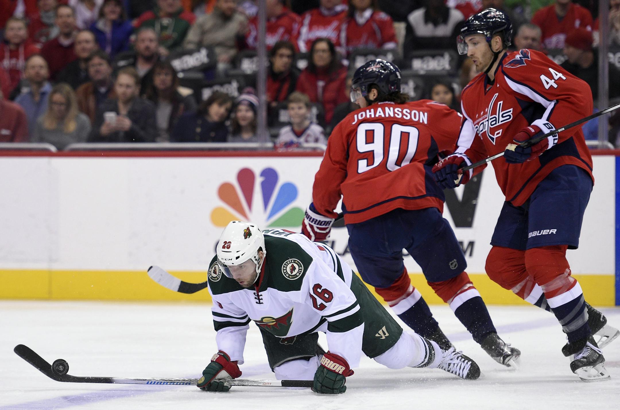 Minnesota Wild left wing Thomas Vanek (26), of Austria, chases the puck against Washington Capitals center Marcus Johansson (90), of Sweden, and Brooks Orpik (44) during the first period of an NHL hockey game Friday, Feb. 26, 2016, in Washington. (AP Photo/Nick Wass)