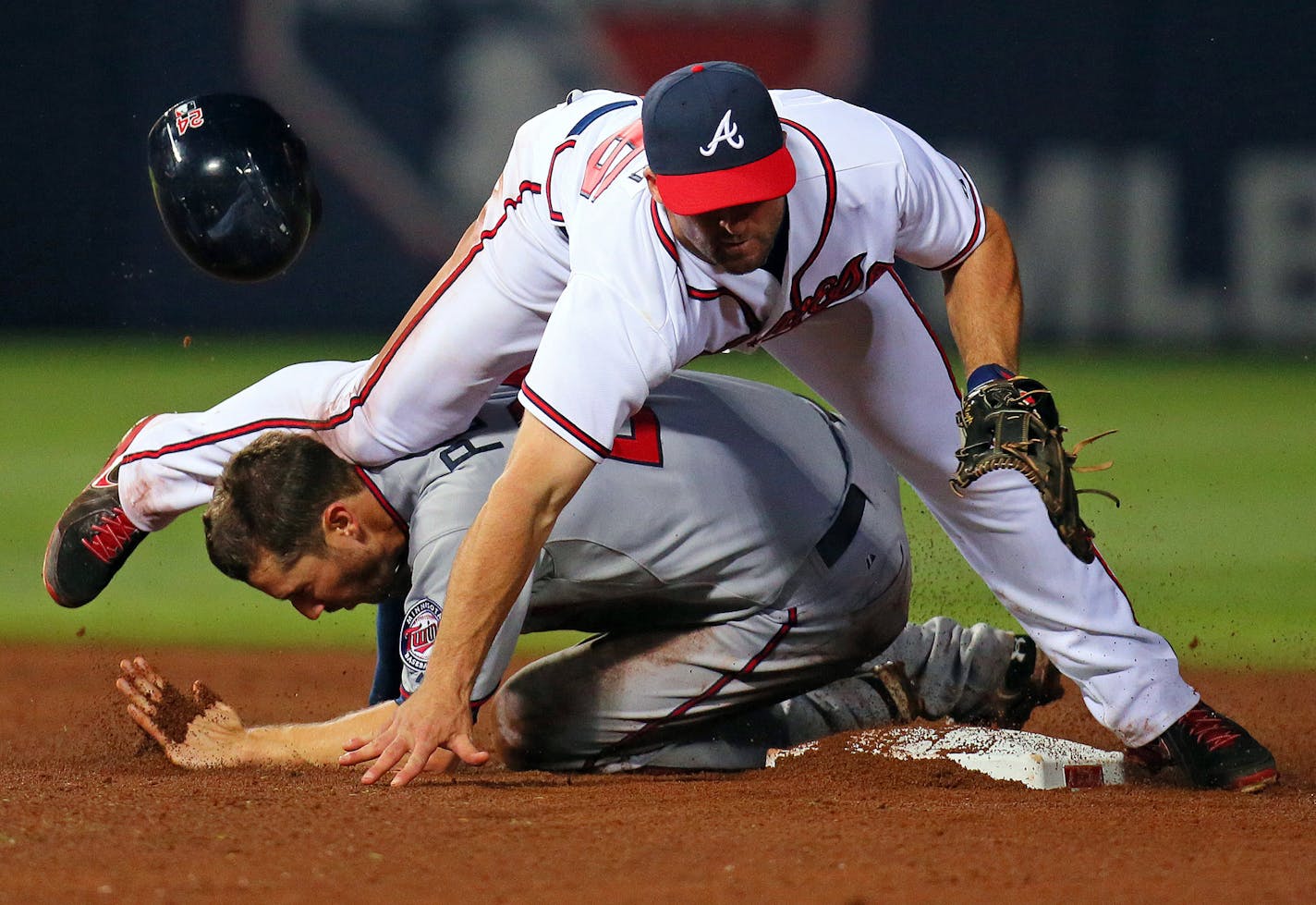 In this Tuesday, May 21, 2013 photo, Minnesota Twins' Trevor Plouffe gets hit in the head by Atlanta Braves second baseman Dan Uggla's shin while Uggla was attempting to turn a double play on a ground ball by Ryan Doumit in the tenth inning of a baseball game in Atlanta. The Twins placed Plouffe on the seven-day disabled list with a concussion Wednesday, May 22, 2013 (AP Photo/Atlanta Journal-Constitution, Curtis Compton) MARIETTA DAILY OUT; GWINNETT DAILY POST OUT; LOCAL TV OUT; WXIA-TV OUT; WG