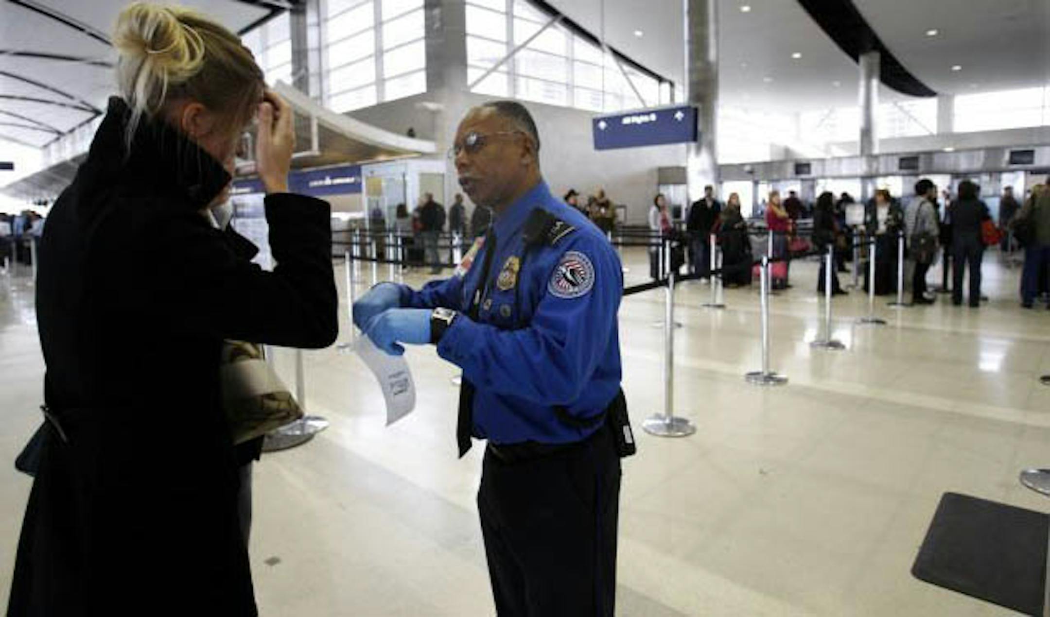 Transportation Security Administration agent Paul Marshall helps an international traveler at the Detroit Metropolitan Airport in Romulus, Mich. on Saturday,. Officials were trying to calm traveler's fears a day after an attempted terrorist attack aboard a Northwest Airlines flight as it was about to land in Detroit.