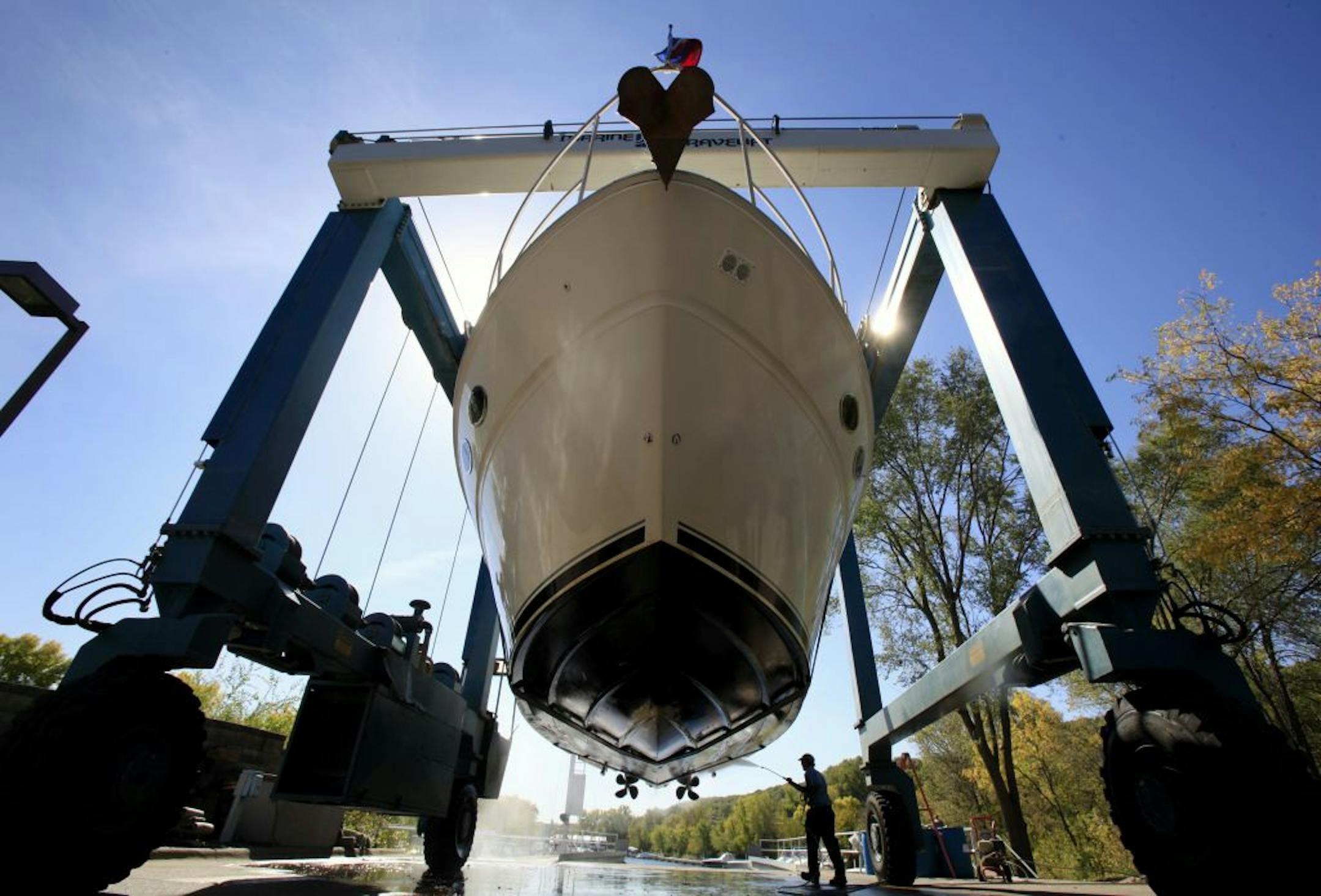 After the boat is lifted out of the water at Bayport Marina, Tom Kislenger uses a high pressure sprayer to clean the bottom side of the boat before it is trailered away and wrapped for storage. Bayport, MN on September 24, 2012.