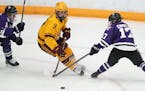 Minnesota forward Taylor Heise (9) took the puck around St. Thomas defenseman Megan Cornell (17) in the first period of an NCAA women’s hockey game 