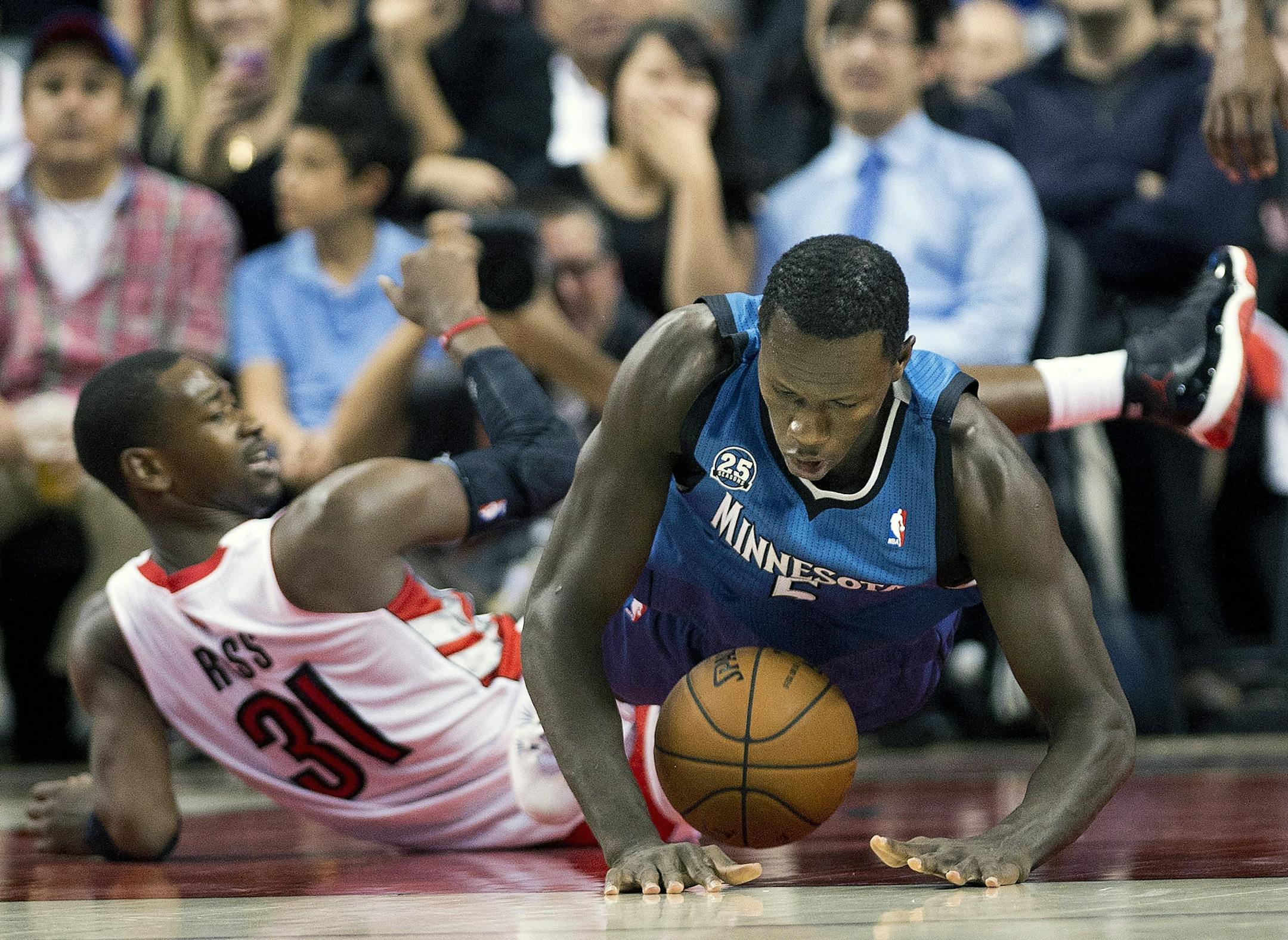 Toronto Raptors forward Terrence Ross, left, trips up Minnesota Timberwolves forward Gorgui Dieng during the second half of an NBA preseason basketball game in Toronto on Wednesday, Oct. 9, 2013.