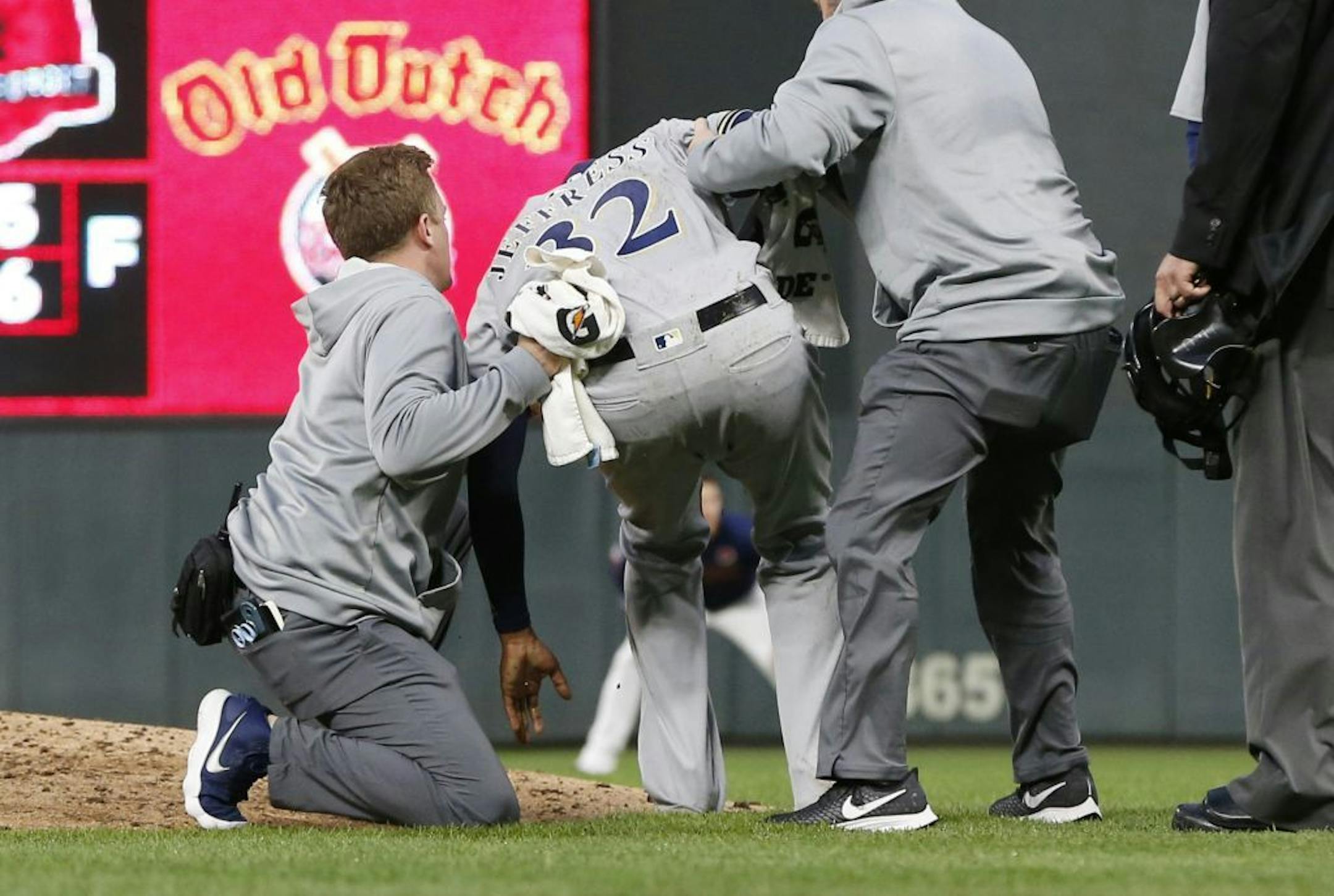 Jeremy Jeffress is helped up after he went down after fielding a line drive by Willians Astudillo.