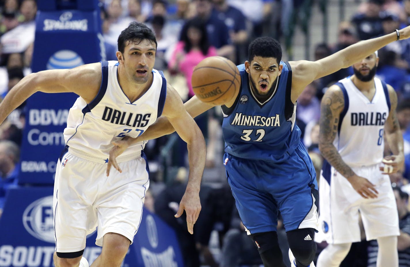 Minnesota Timberwolves center Karl-Anthony Towns (32) and Dallas Mavericks center Zaza Pachulia (27) chase a loose ball during the second half of an NBA basketball game, Sunday, Feb. 28, 2016, in Dallas. The Mavericks won 128-101. (AP Photo/LM Otero)