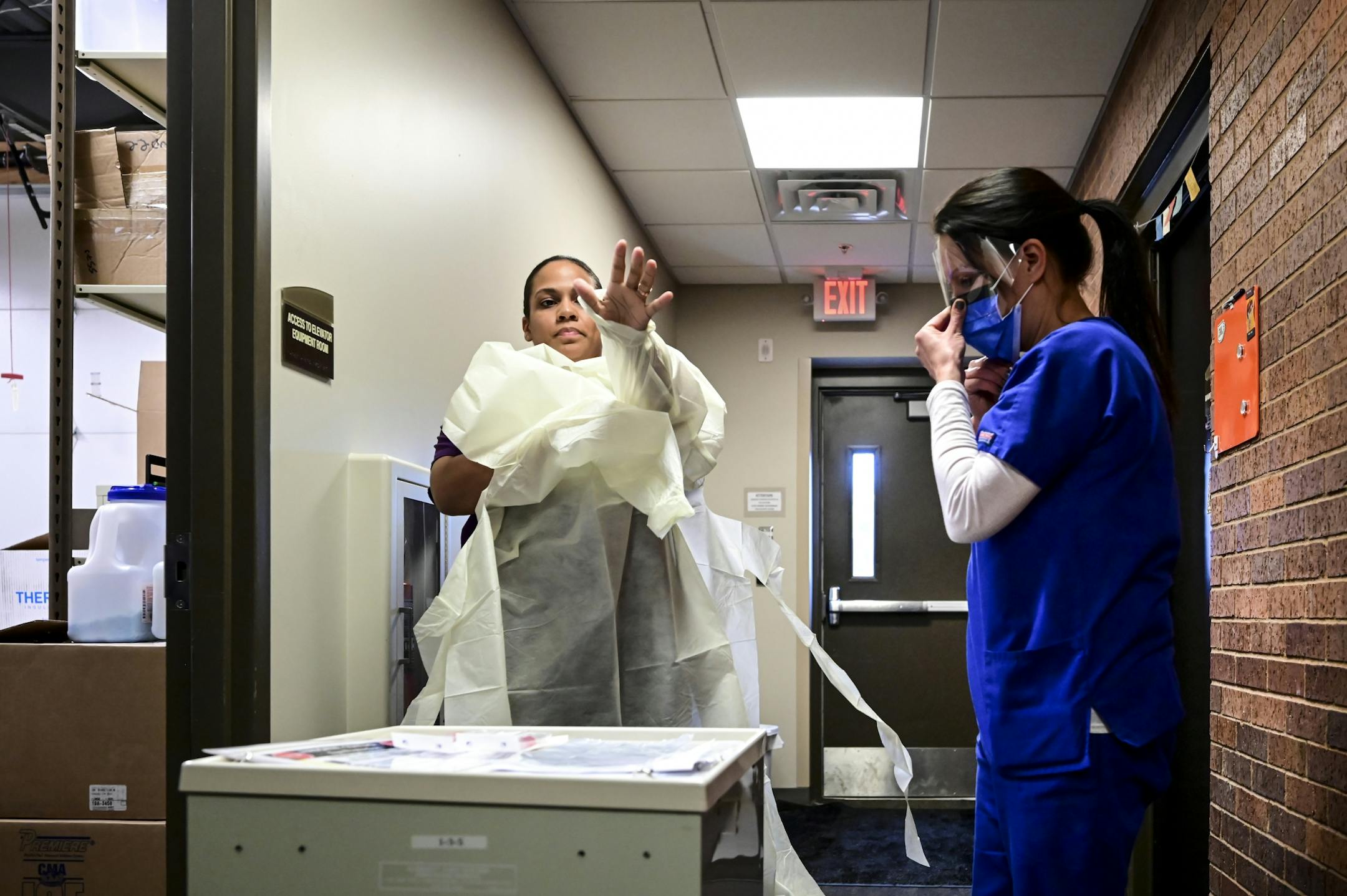M Health Fairview Medical Assistants Reece Wallaker, left, and Sandy Graves, put on protective equipment prior to Tuesday's demonstration.