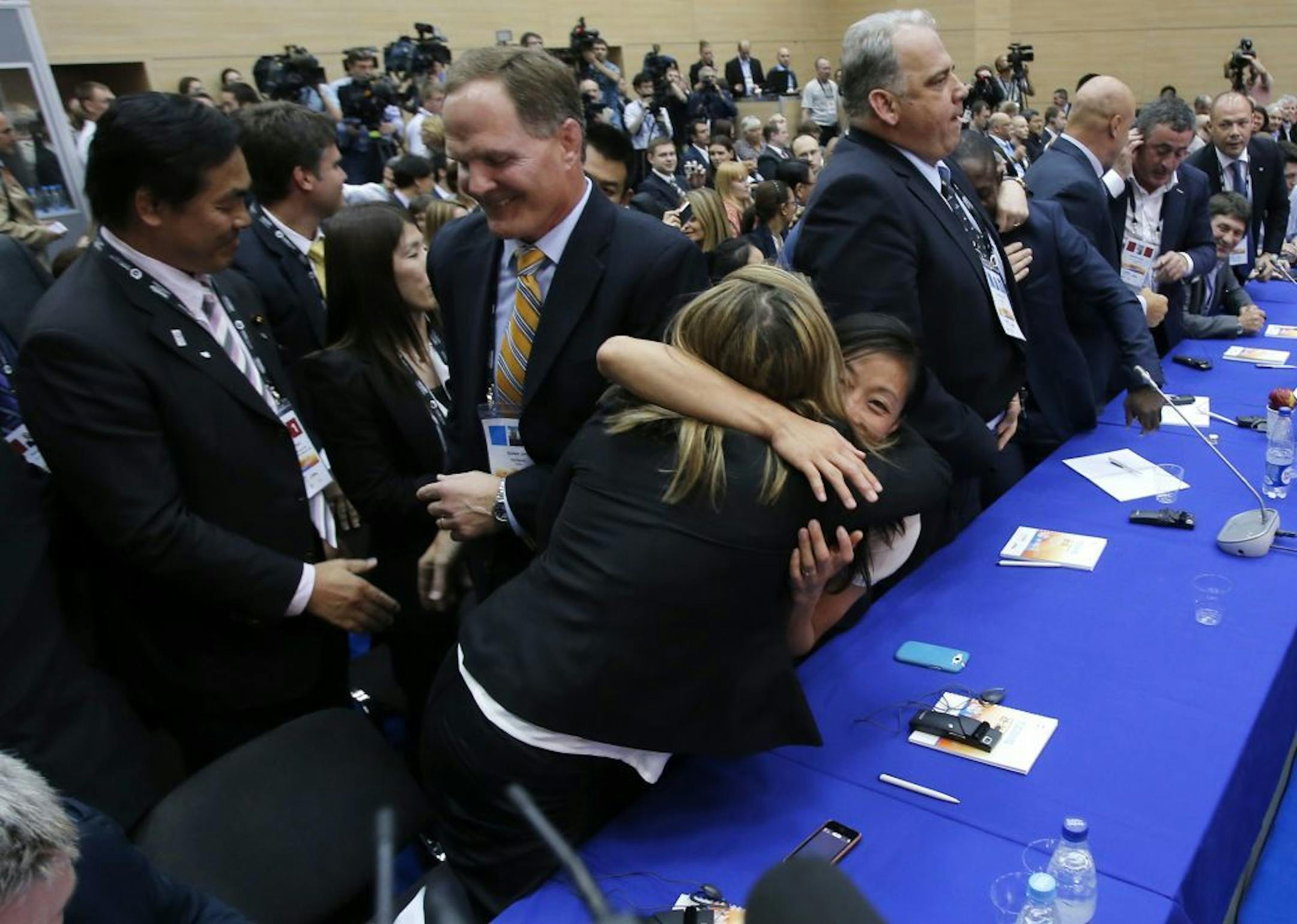 Members of International Wrestling federation react after the wrestling was announced one of the three candidate sports for the 2020 Olympics at the SportAccord International Convention in St.Petersburg, Russia, Wednesday, May 29, 2013. Three months after being dropped from the 2020 Olympics, wrestling won a reprieve Wednesday and made the IOC shortlist for inclusion in the games.