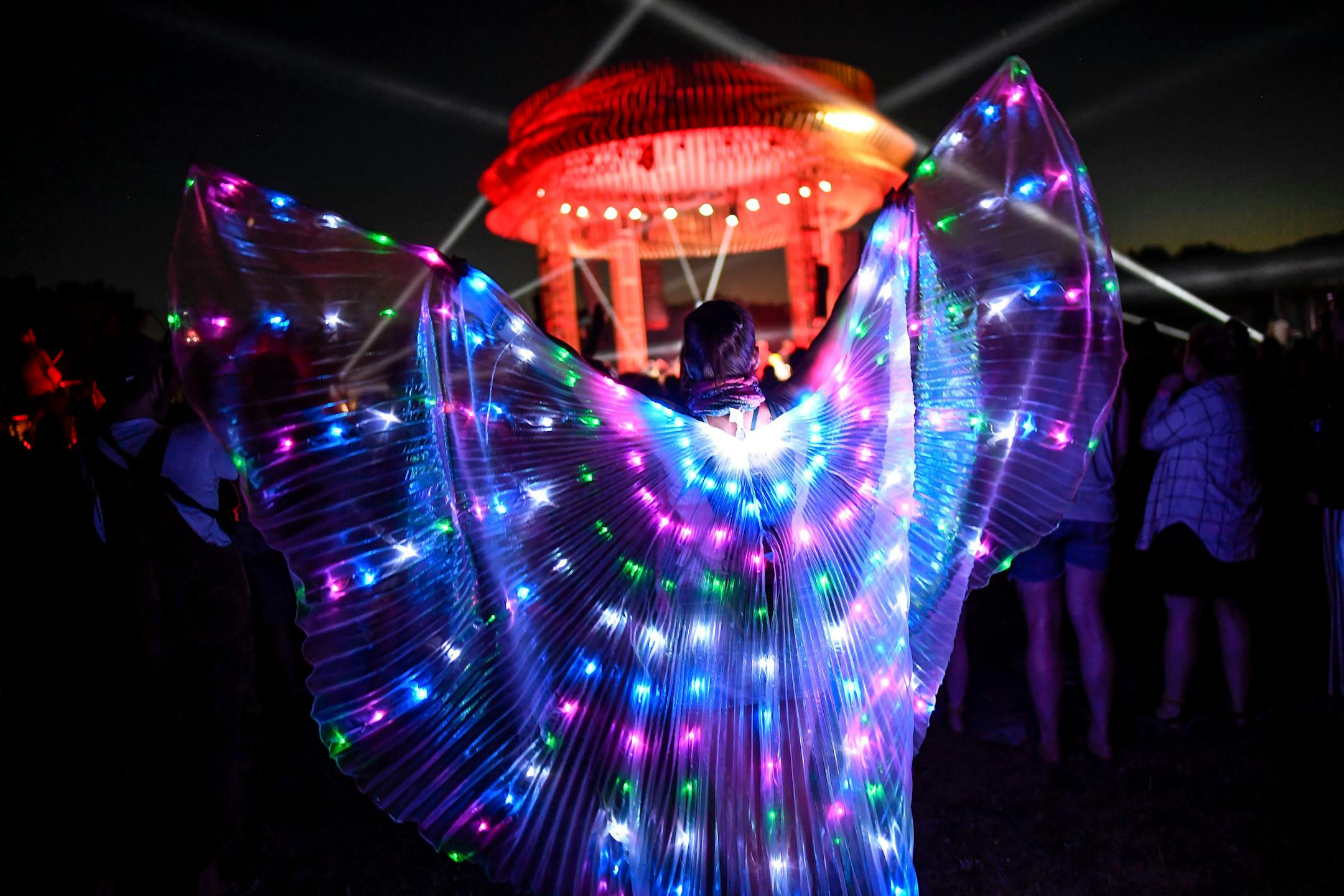 Melissa Nauertz, of Madison, Wisc., danced near the FLAMBEAUX stage wearing a light up cape as The National performed Saturday night. ] AARON LAVINSKY ï aaron.lavinsky@startribune.com Day two of the Eaux Claires Music & Art Festival was held Saturday, July 7, 2018 at Foster Farms in Eau Claire, Wisc.