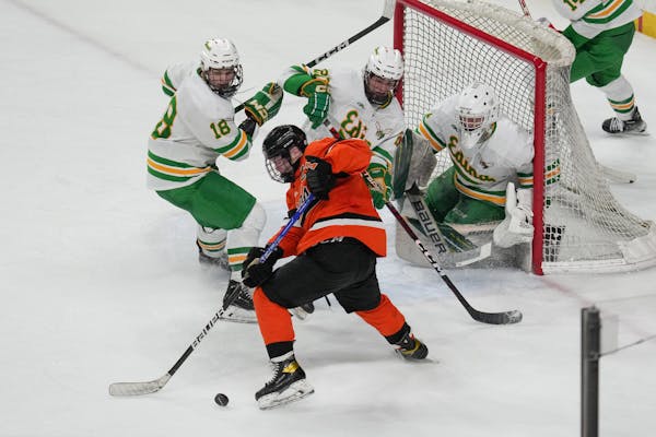 Edina's net was heavily guarded in the third period as Moorhead defenseman Colby Krier (5) reached for the puck during the MSHSL Class 2A quarterfinal