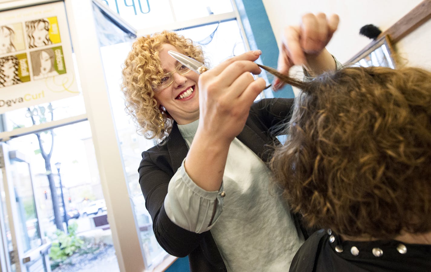 Co-owner Kristy Wilson cuts a customer's hair at Uptown Curl in Minneapolis October 24, 2014. Wilson and her staff only cut dry curly hair; never wet. (Courtney Perry/Special to the Star Tribune)