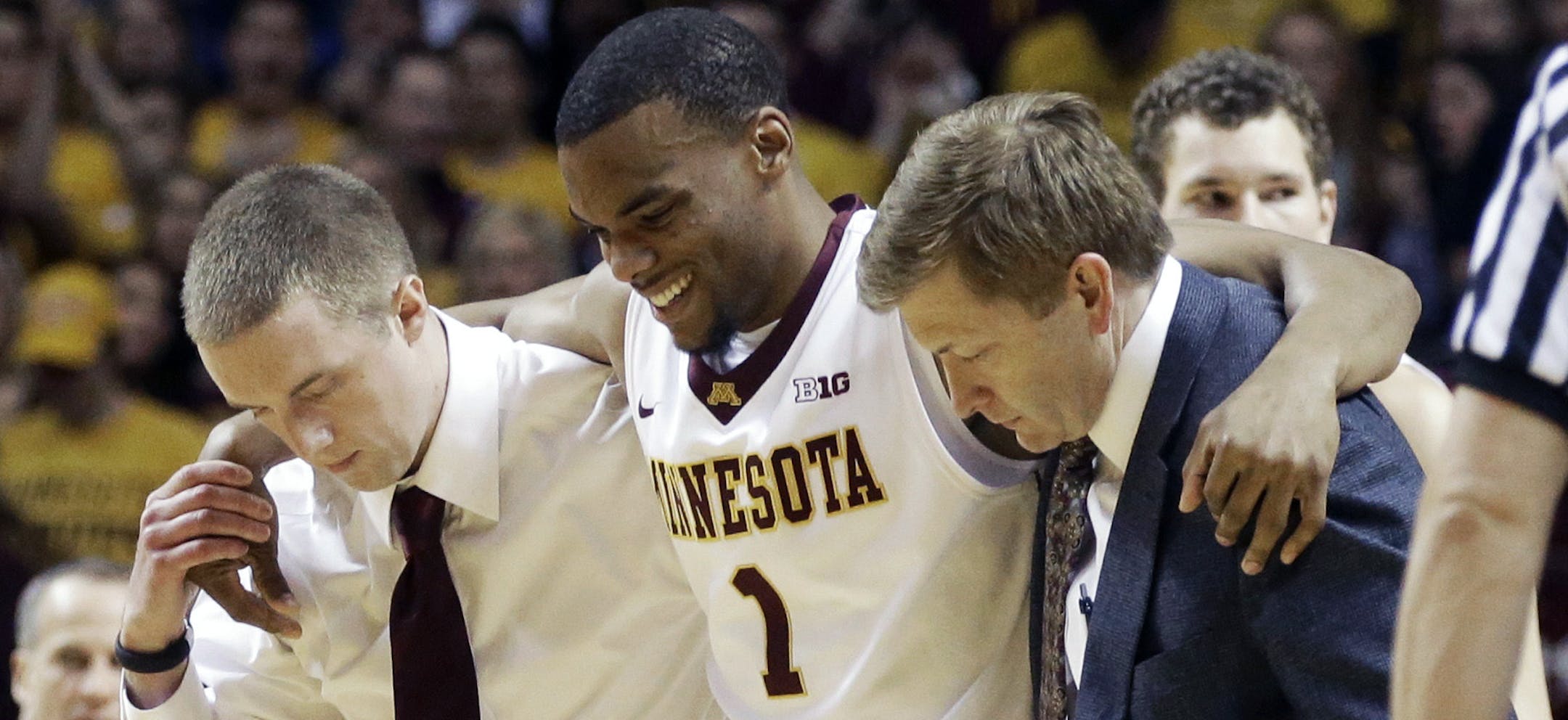 Minnesota's Andre Hollins grimaces after being helped off the floor following an injury in the first half of an NCAA college basketball game against Wisconsin, Wednesday, Jan. 22, 2014, in Minneapolis. (AP Photo/Jim Mone)