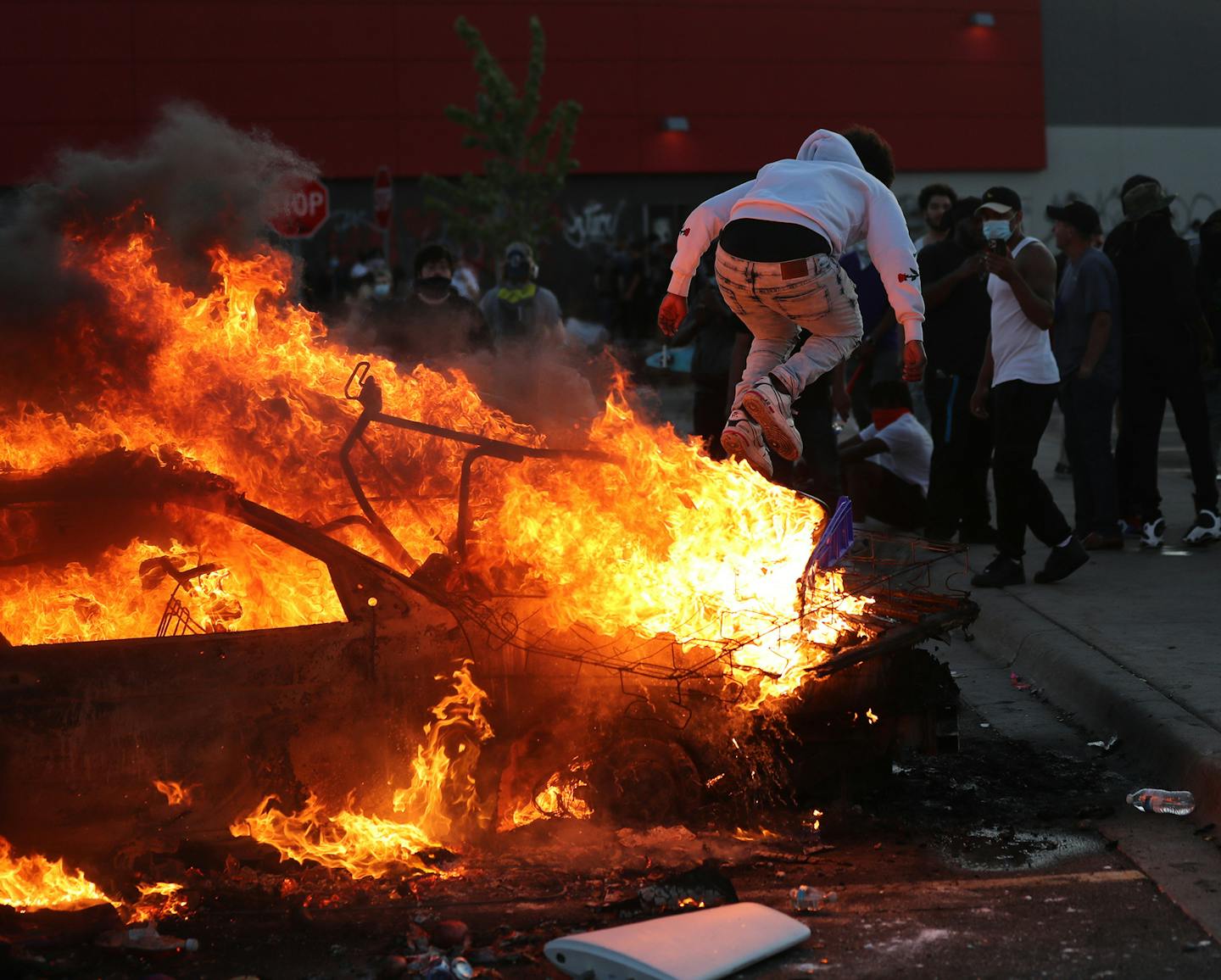 A man jumps off of a burning car among demonstrators in the streets in Minneapolis during a third night of protests following the death of George Floyd while in Minneapolis police custody, on Thursday, May 28, 2020. (David Joles/Minneapolis Star Tribune/TNS) ORG XMIT: 1673282