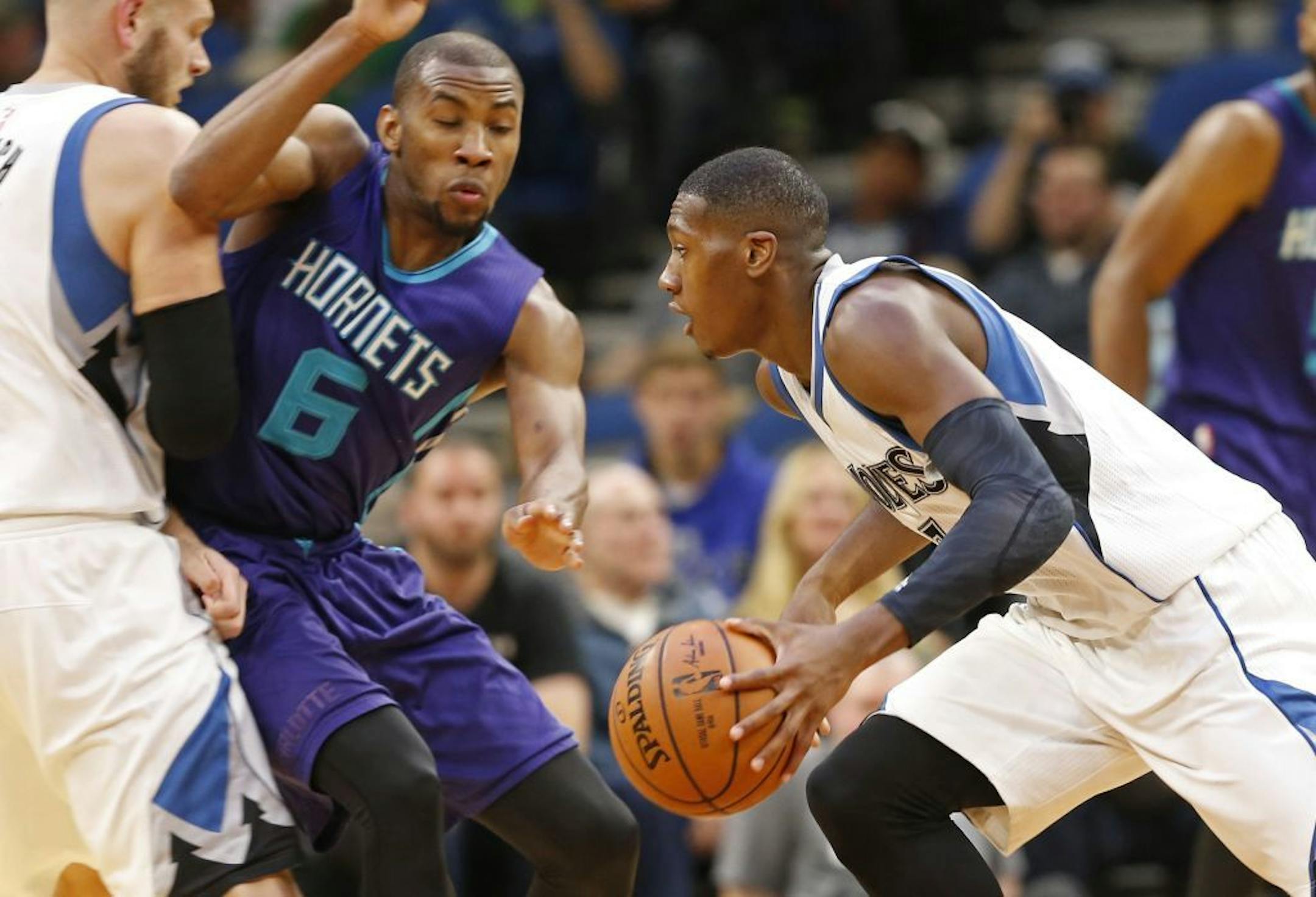 Minnesota Timberwolves' Kris Dunn, right, drives as Nemanja Bjelica, left, sets a pick on Charlotte Hornets' Rasheed Sulaimon during the second half of an NBA preseason basketball game Friday, Oct. 21, 2016, in Minneapolis.