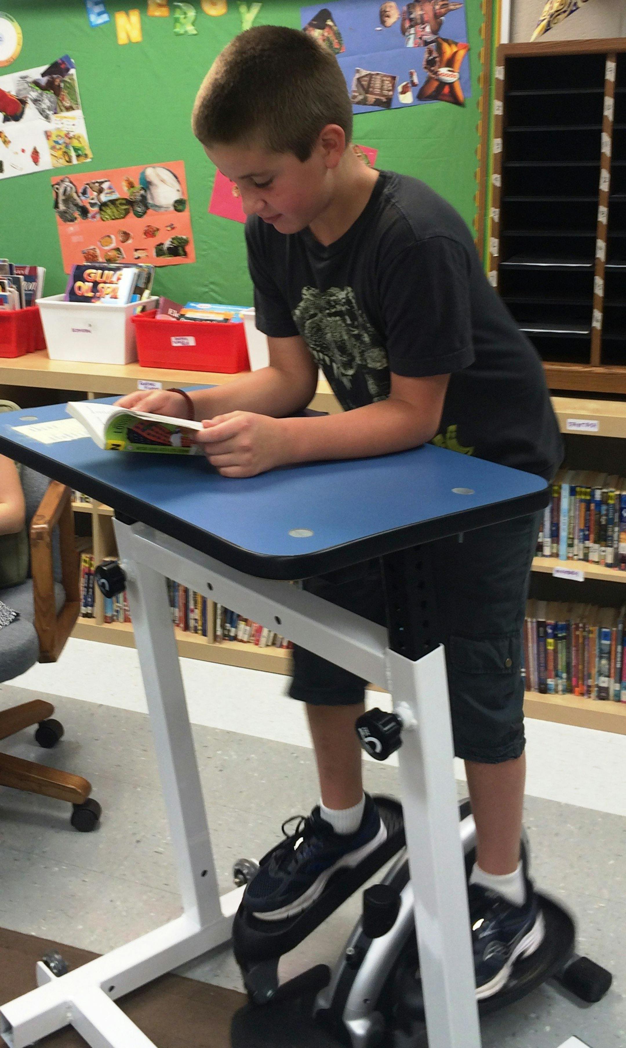 Students at Windsor Elementary School in Arlington Heights, Ill., including Adam Boesen, 10, are learning this year with the help of so-called classroom fit stations, including standing desks, exercise bikes and elliptical machines. (Karen Ann Cullotta/Chicago Tribune/TNS) ORG XMIT: 1173826