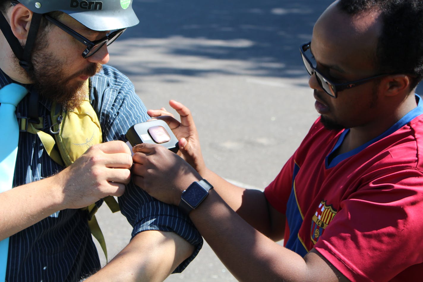 Minneapolis Health Department Employee Ahmed Hashi affixes other city staffers with air quality monitors before a test ride in Northeast Minneapolis.