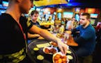 Chadwick Hamblin delivered wings to customers Frank Koslucher and Justin Munafo at the Buffalo Wild Wings at the University of Minnesota on March 20, 