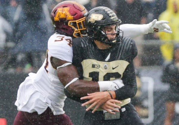 Gophers defensive lineman Boye Mafe pulled down Purdue quarterback Aidan O’Connell for a first-quarter sack Saturday in West Lafayette, Ind.