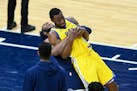 Minnesota Timberwolves forward Josh Okogie (20) gave an unexpected lift to fellow teammate Golden State Warriors forward Andrew Wiggins (22) after Thu