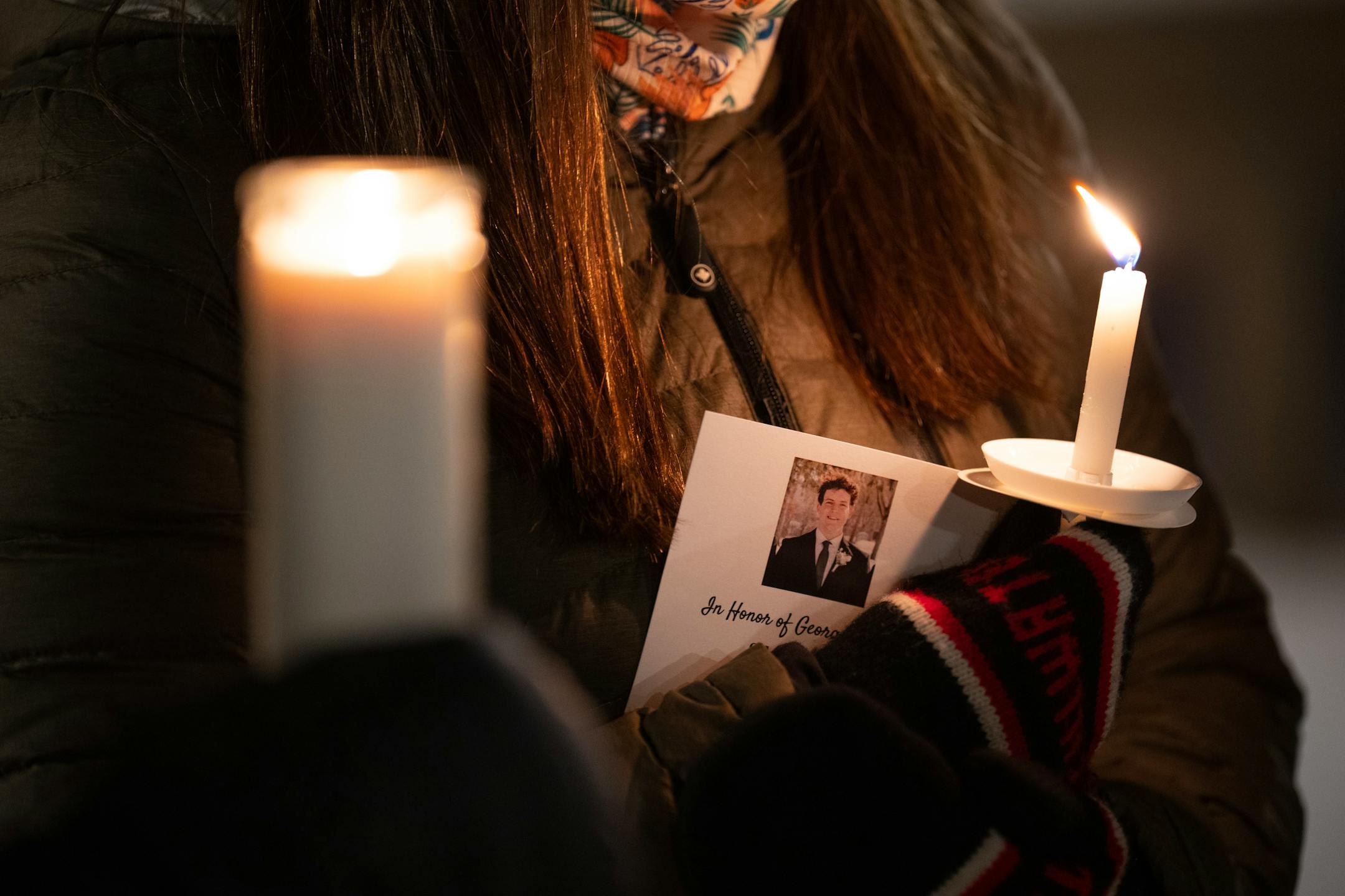 Friends and community members held candles at a vigil held Monday night, Dec. 26, 2022, on the plaza next to the lift bridge in Stillwater to honor the memory of 20-year-old college student George Musser.