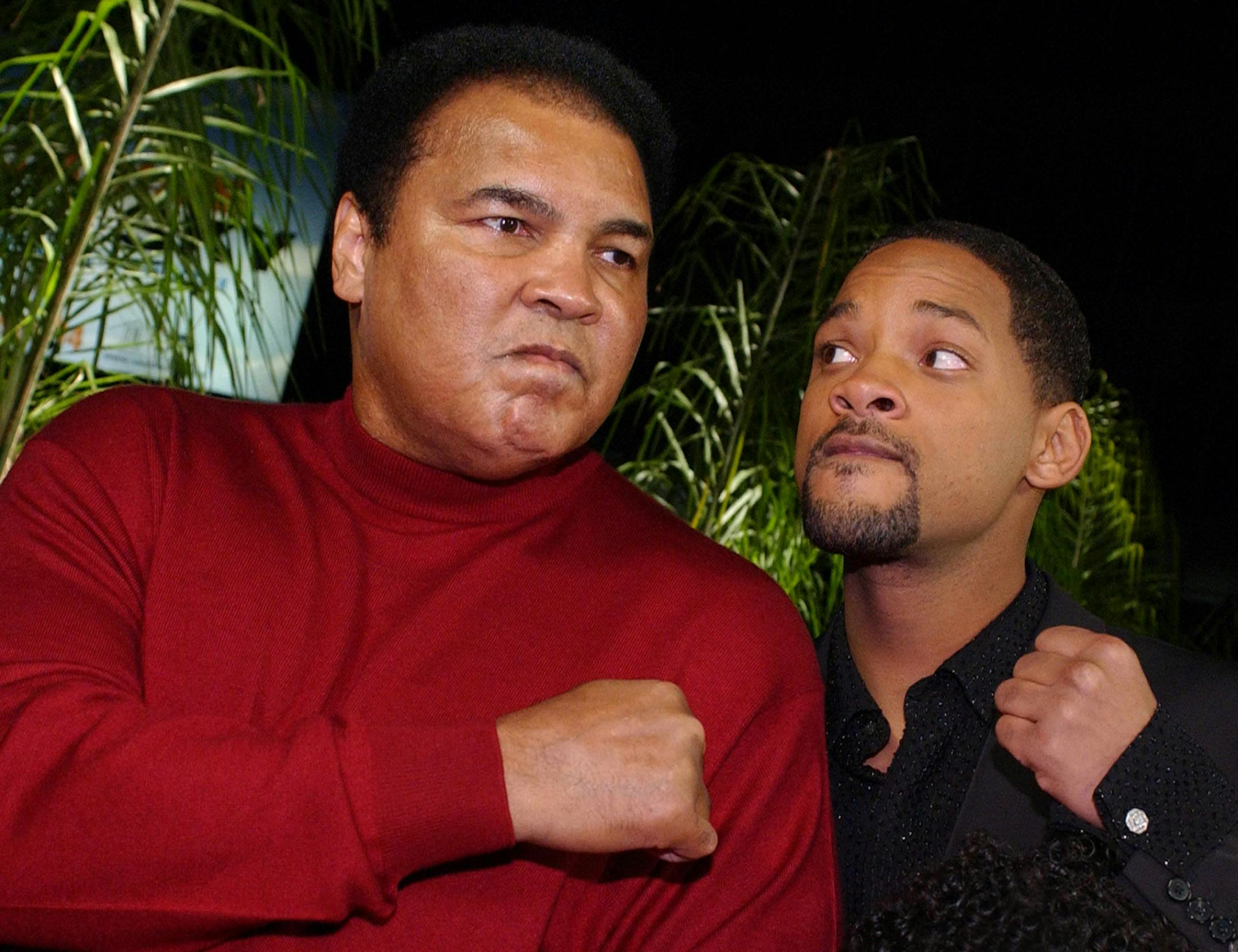 US former world heavyweight boxing champion Muhammad Ali (L) jokes with US actor Will Smith (R) who portrays him in new film "Ali," at the movie's premiere in Hollywood, CA, 12 December 2001. AFP PHOTO/Lucy NICHOLSON