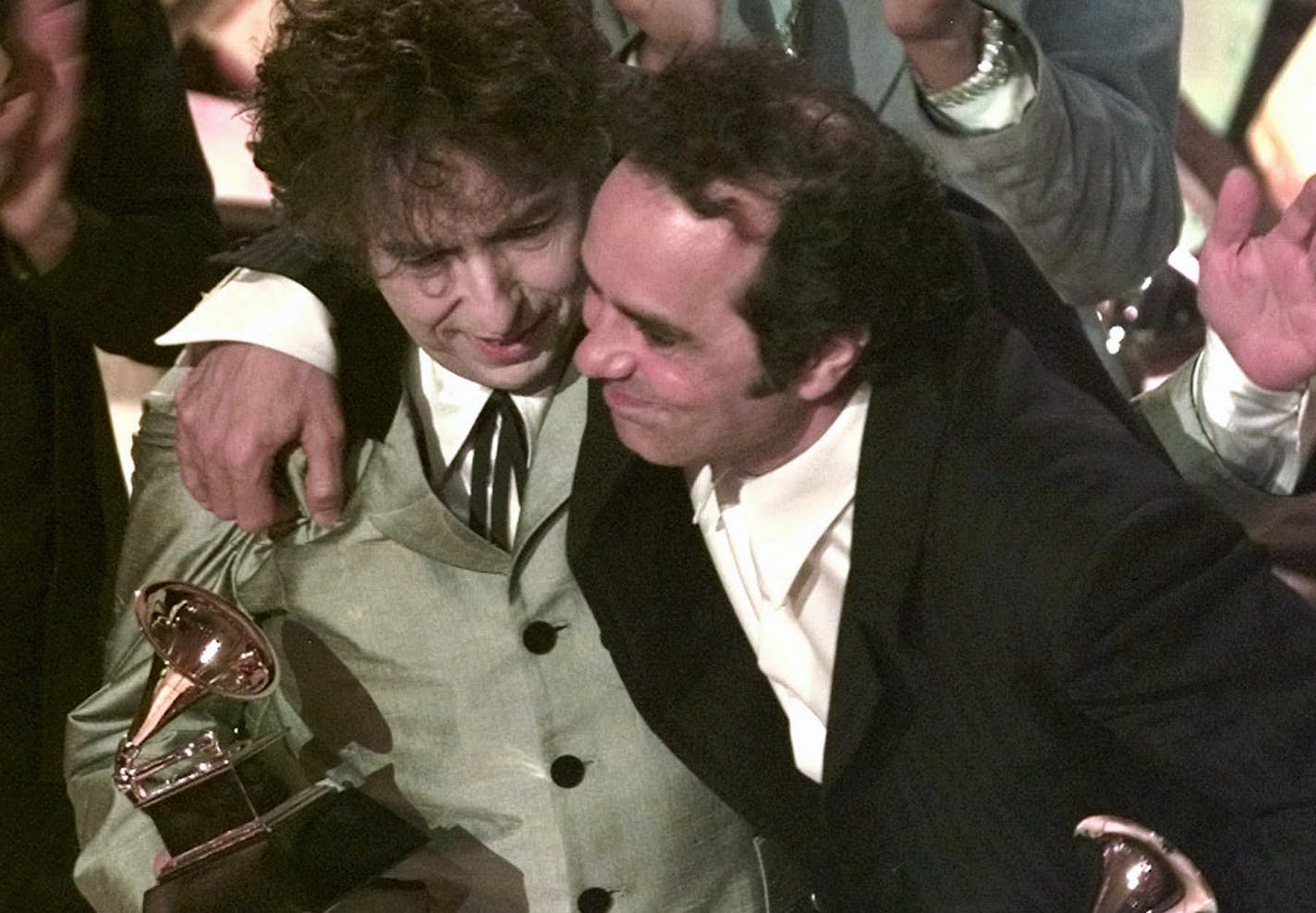 Bob Dylan, left, and his producer, Daniel Lanois, hug after Dylan won Album of the Year for "Time Out of Mind" at the 40th Annual Grammy Awards Wednesday, Feb. 25, 1998, at Radio City Music Hall in New York. (AP Photo/Mark Lennihan) ORG XMIT: XNYR131