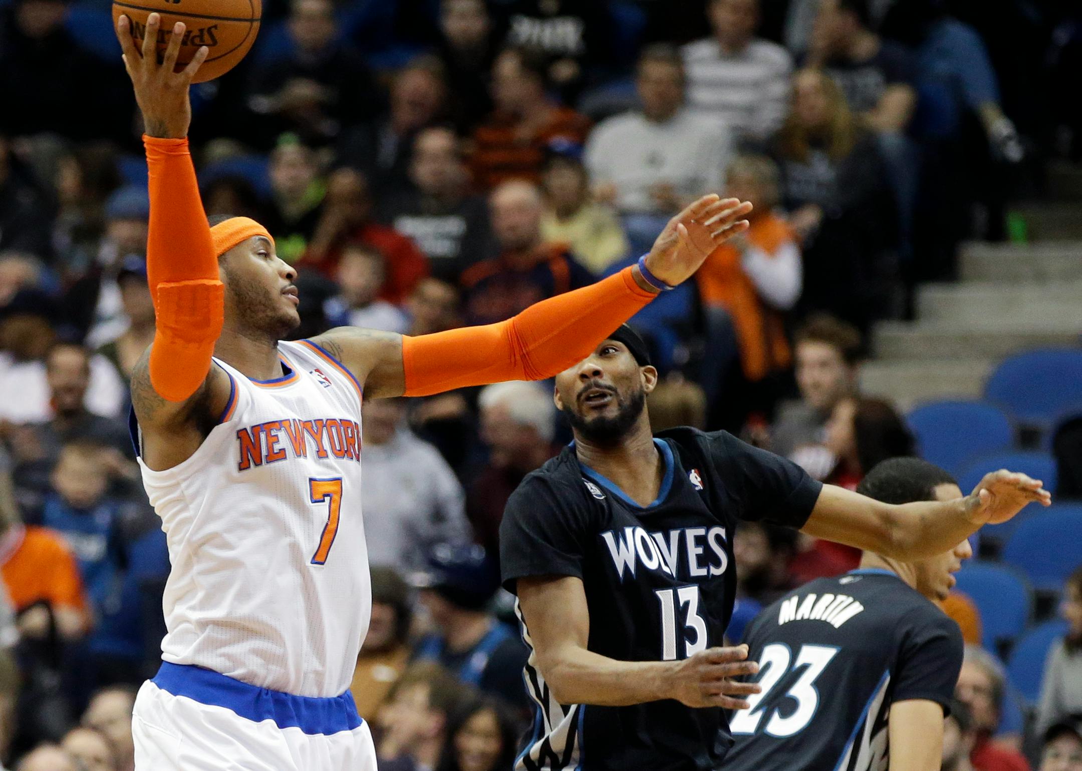 New York Knicks' Carmelo Anthony, left, beats Minnesota Timberwolves' Corey Brewer to a pass in the first quarter of an NBA basketball game, Wednesday, March 5, 2014, in Minneapolis. (AP Photo/Jim Mone)