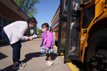 Principal Anne Gattman took students’ temperatures as they arrived at St. Jerome School in Maplewood.