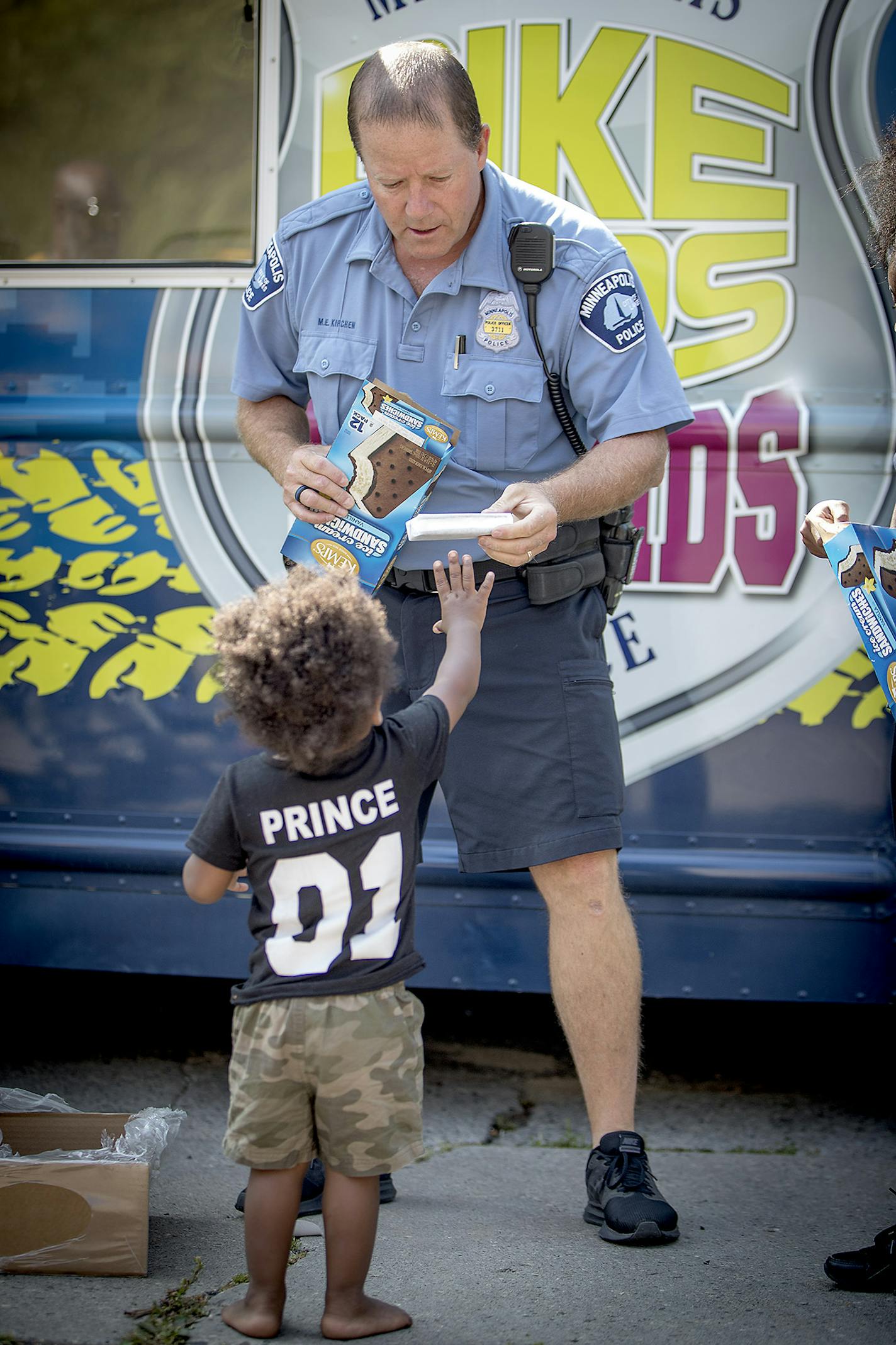 Minneapolis Police Officer Michael Kirchen greeted folks and handed out ice cream during a community outreach BBQ, Thursday, August 24, 2017 in Minneapolis, MN. Bike Cops 4 Kids, a long-running community engagement program that helps at-risk kids, giving away bikes and equipment, hosting events and even showing up at murder scenes to show a different face of the department. ] ELIZABETH FLORES &#xef; liz.flores@startribune.com