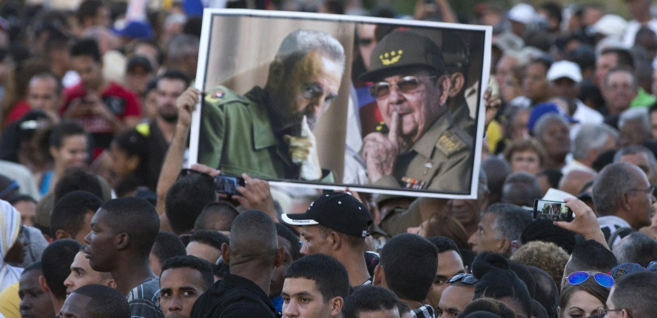 Cubans hold a picture of Fidel and Raul Castro, right, as they attend a rally at the Revolution Plaza in Havana, Cuba, Tuesday, Nov. 29, 2016. Schools and government offices were closed Tuesday for a second day of homage to Fidel Castro, with the day ending in a rally on the wide plaza where the Cuban leader delivered fiery speeches to mammoth crowds in the years after he seized power. Fidel Castro passed away Friday Nov. 25. He was 90.(AP Photo/Ricardo Mazalan) ORG XMIT: MIN2016120115180123