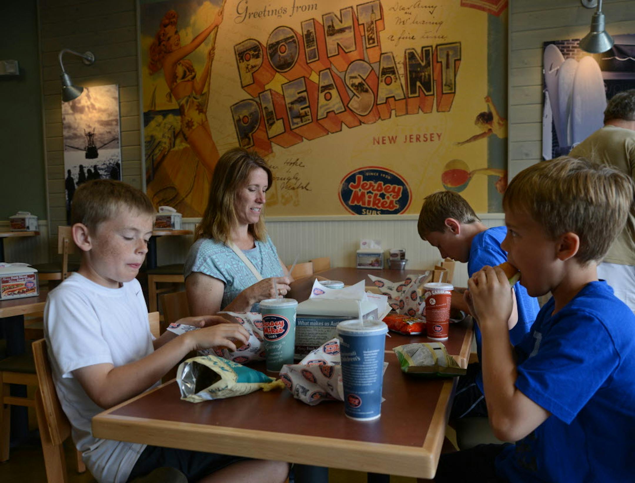Laurie Sonstegard and her sons, Max and Jack, and a family friend, Alexander Brazones, dig into sandwiches at Jersey Mike's in Blaine.