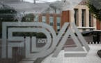 This 2018 fie photo shows the U.S. Food and Drug Administration building behind FDA logos at a bus stop on the agency's campus in Silver Spring, Md. (