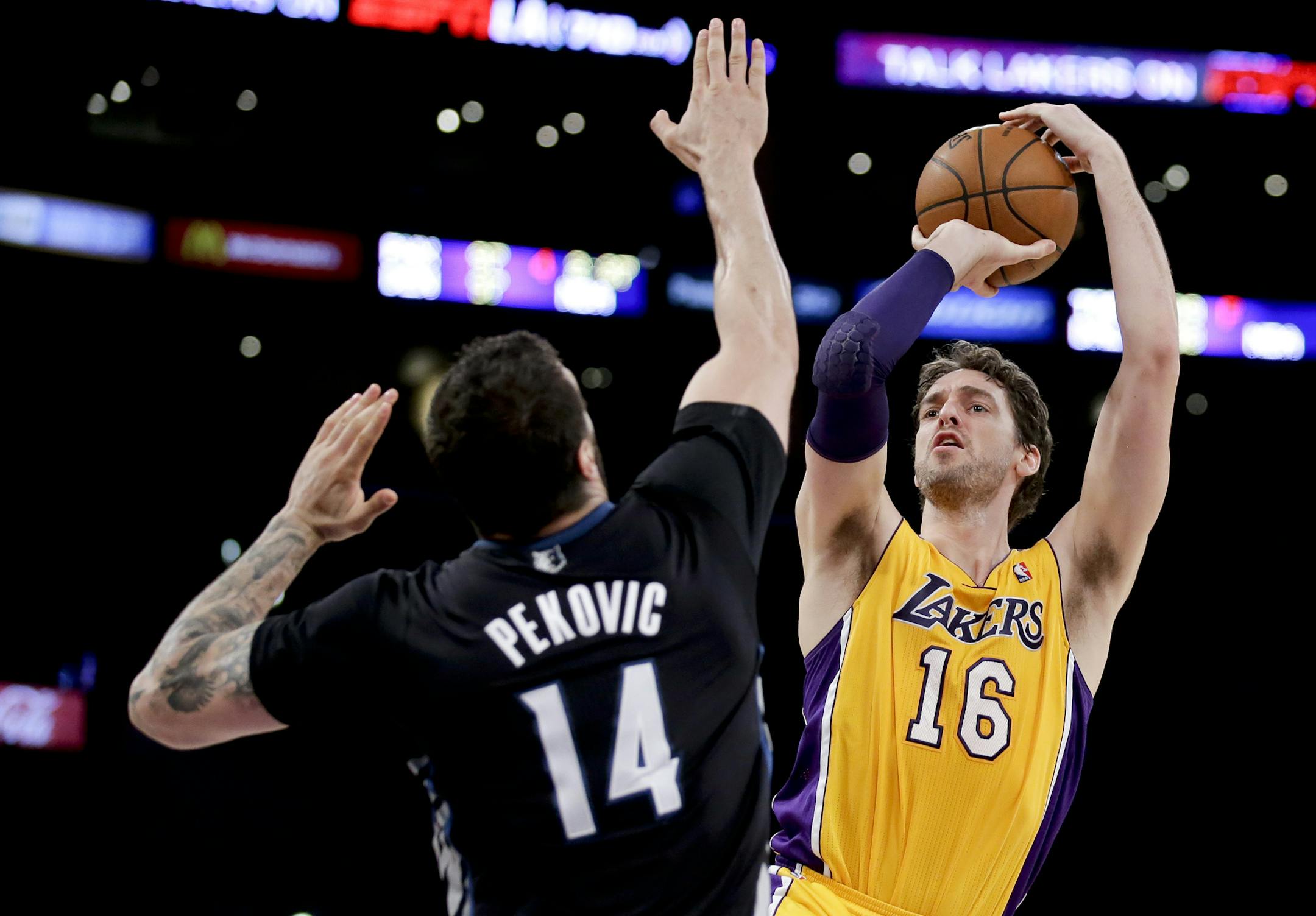 Los Angeles Lakers center Pau Gasol shoots over Minnesota Timberwolves center Nikola Pekovic during the first half of an NBA basketball game in Los Angeles, Friday, Dec. 20, 2013. (AP Photo/Chris Carlson)