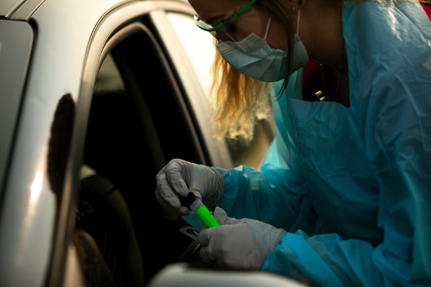 In this Aug. 24, 2020, file photo, Lindsey Helkenn, a medical lab technician from Spearfish, conducts a COVID-19 test in Sturgis, S.D.