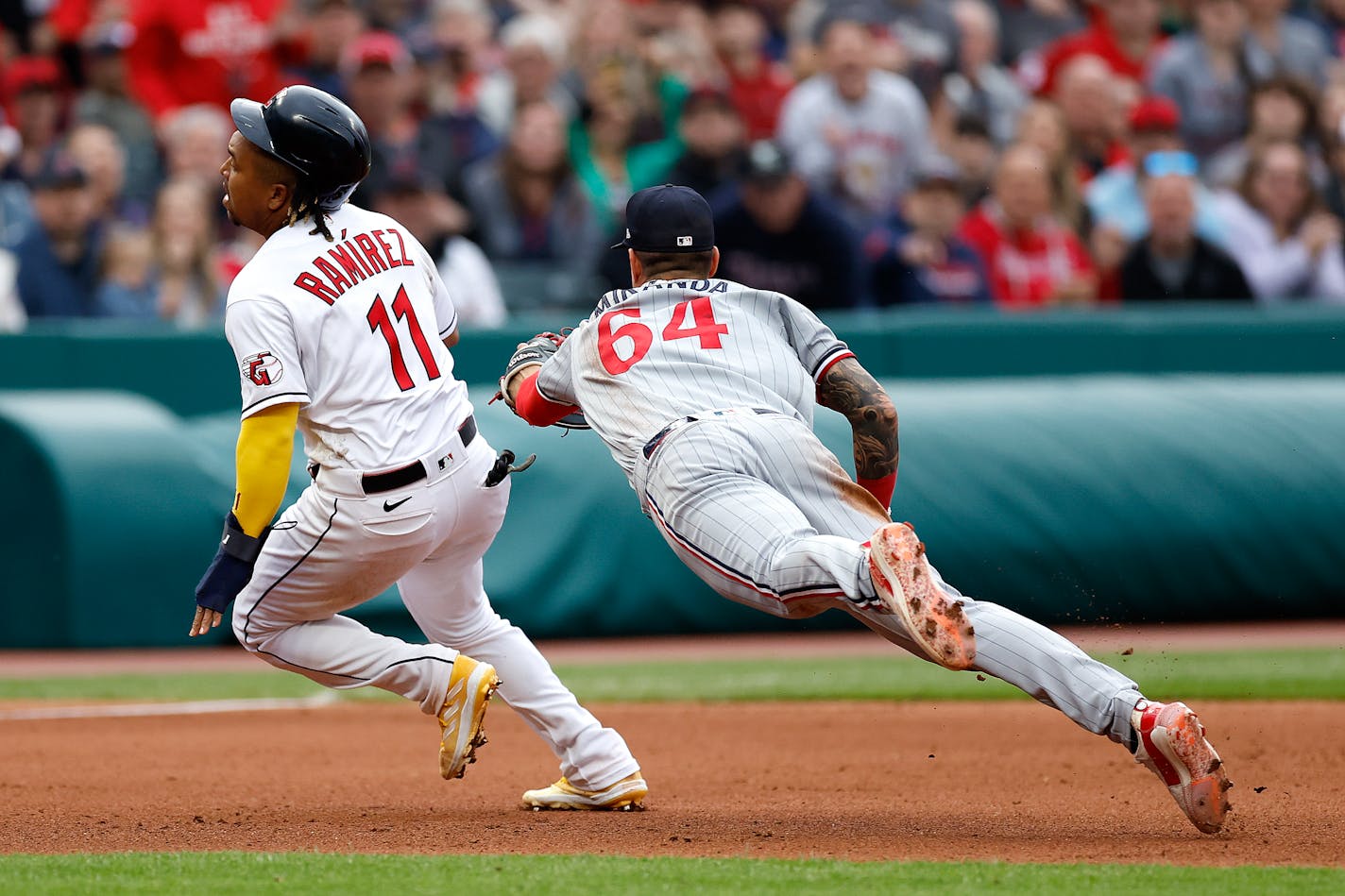 Cleveland's Jose Ramirez avoids a tag by Twins third baseman Jose Miranda on an error during the fourth inning