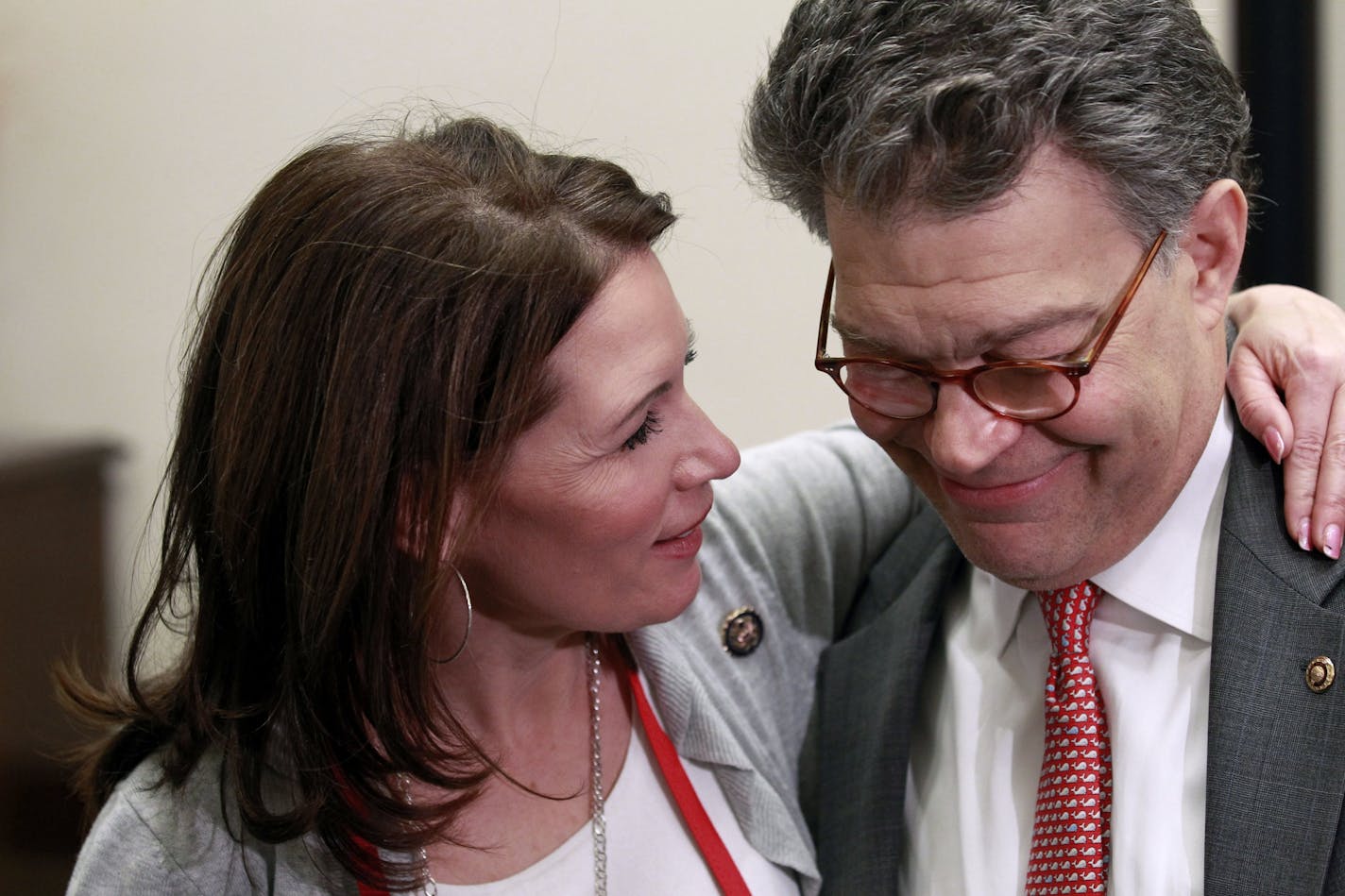 In this Jan. 26, 2011 file photo, Rep. Michele Bachmann, R-Minn., left, talks with Sen. Al Franken, D-Minn., during the "Hot Dish Off," cooking contest in Franken's office on Capitol Hill in Washington,