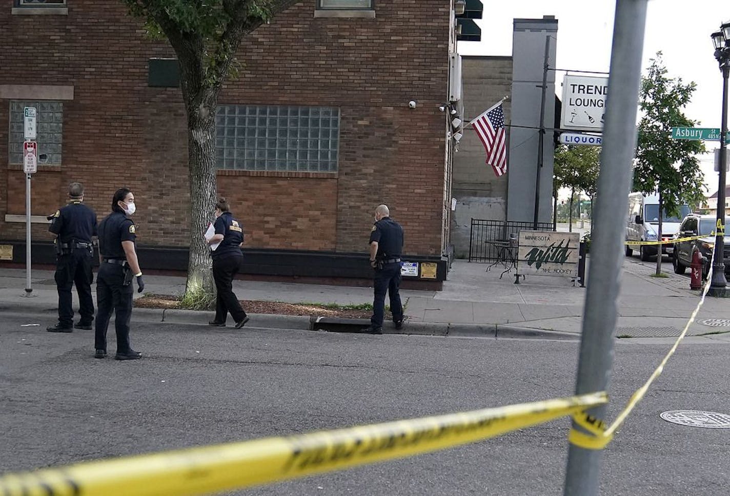 St. Paul law enforcement officers investigate the scene where a woman was shot in the early morning outside the Trend Lounge and later died at Regions Hospital Wednesday in St. Paul.