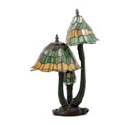 This lamp's maker has not been identified, but it resembles the famous Tiffany lamps of the early 20th century. Its mushroom motif and narrow, asymmet
